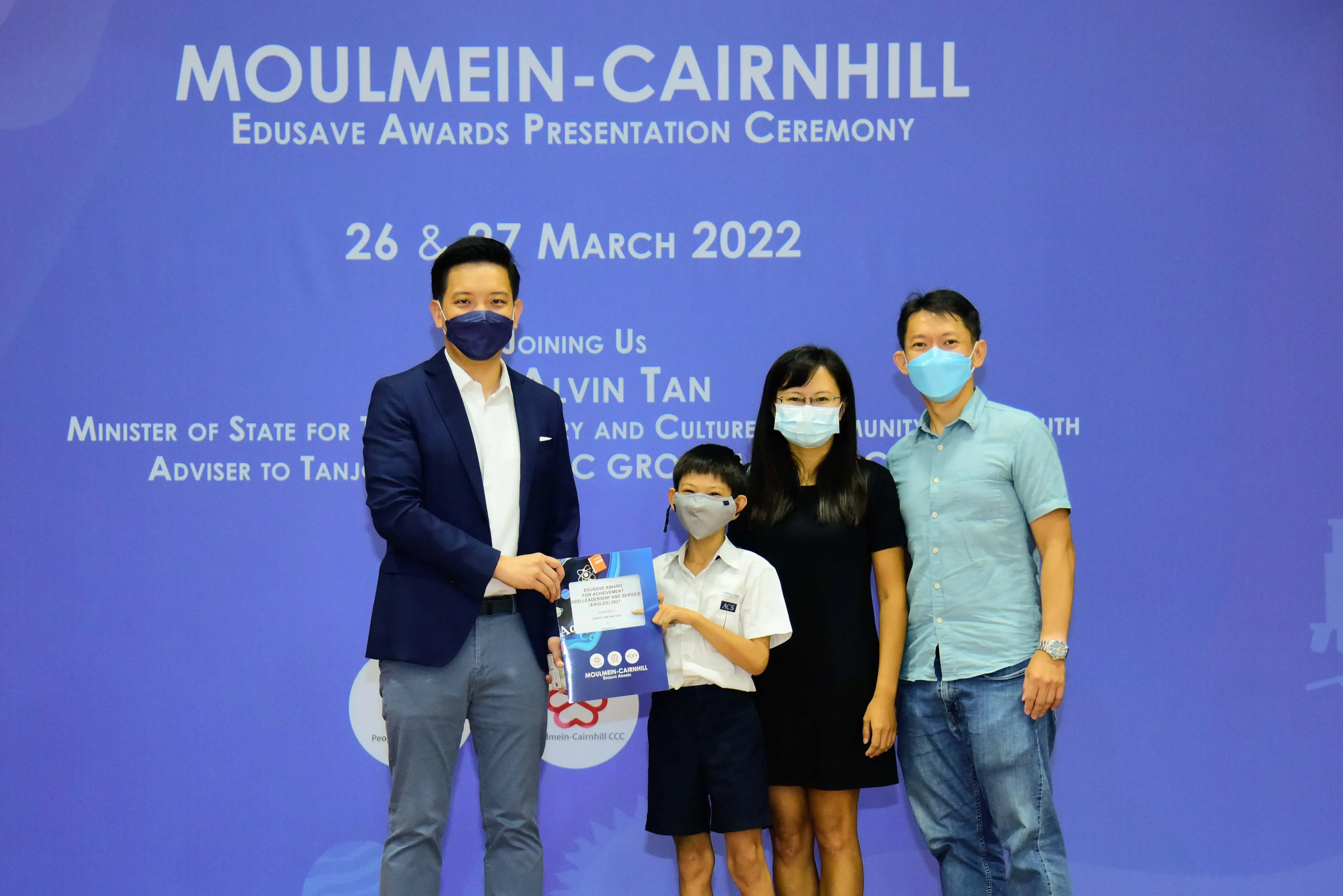 Four masked people pose at the Moulmein-Cairnhill Edusave Awards Presentation Ceremony on 26-27 March 2022.