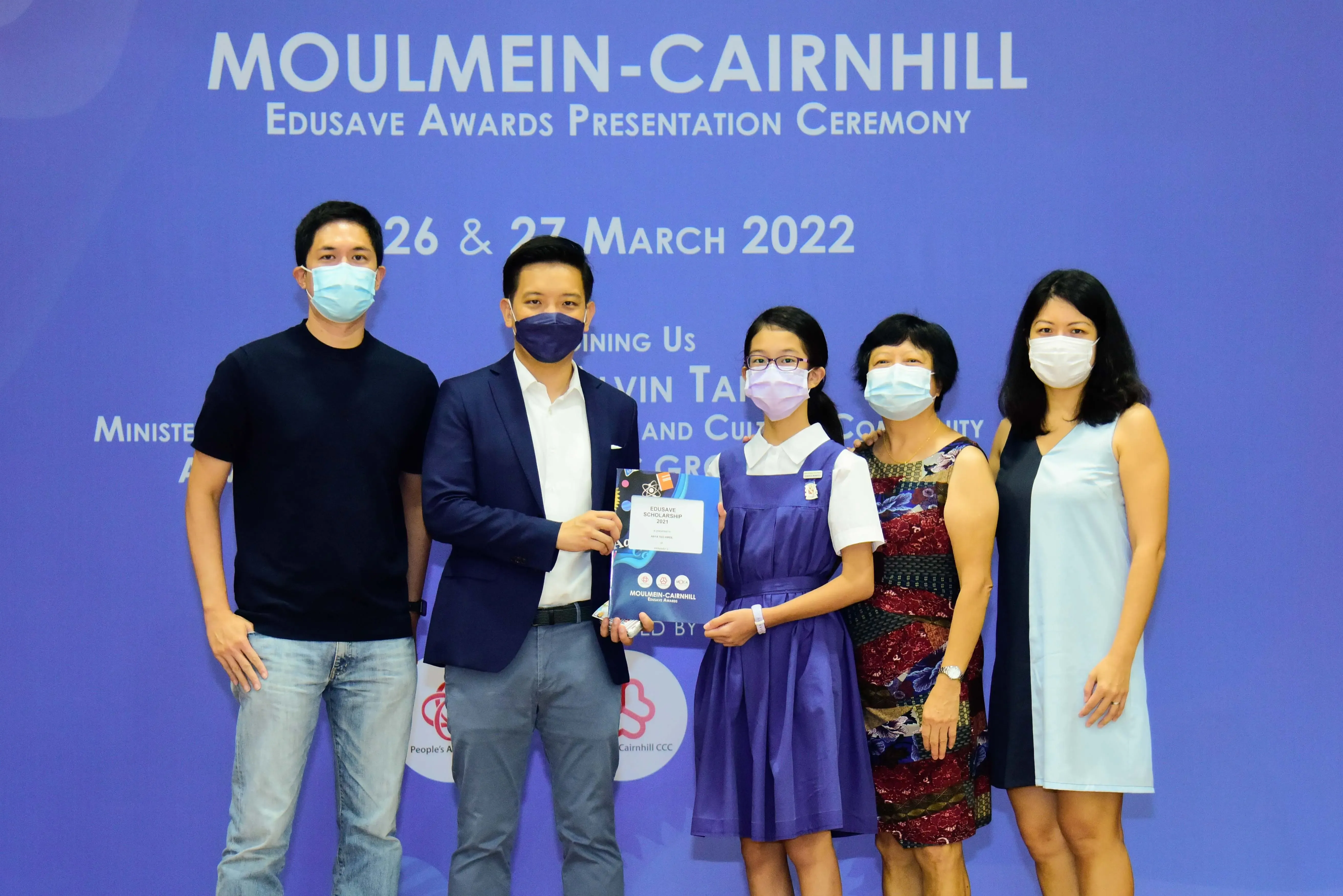 Five masked people pose at the Moulmein-Cairnhill Edusave Awards Presentation Ceremony on 26-27 March 2022.