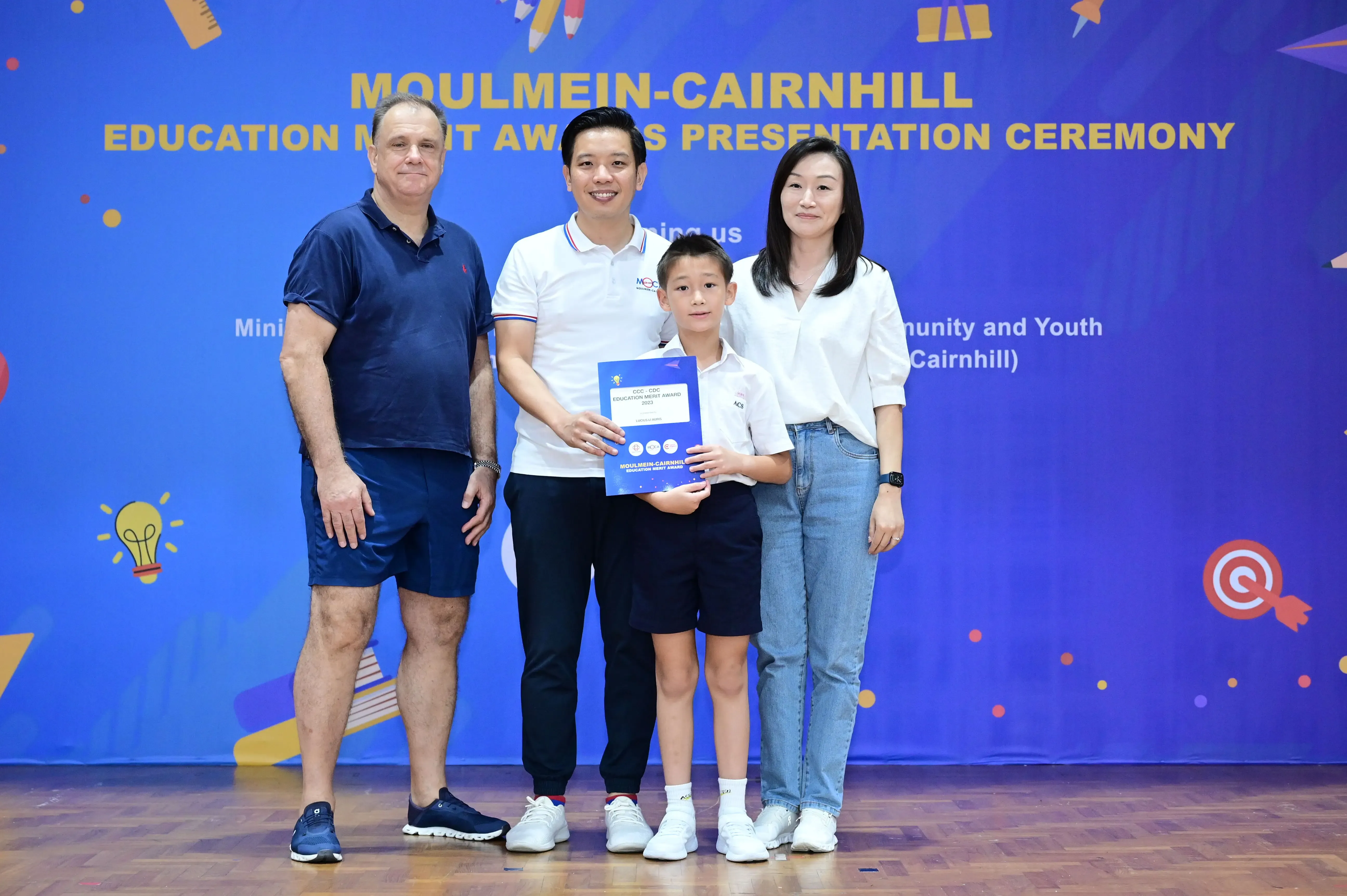 Four people pose with an award certificate at the Moulmein-Cairnhill Education Merit Awards Presentation Ceremony.