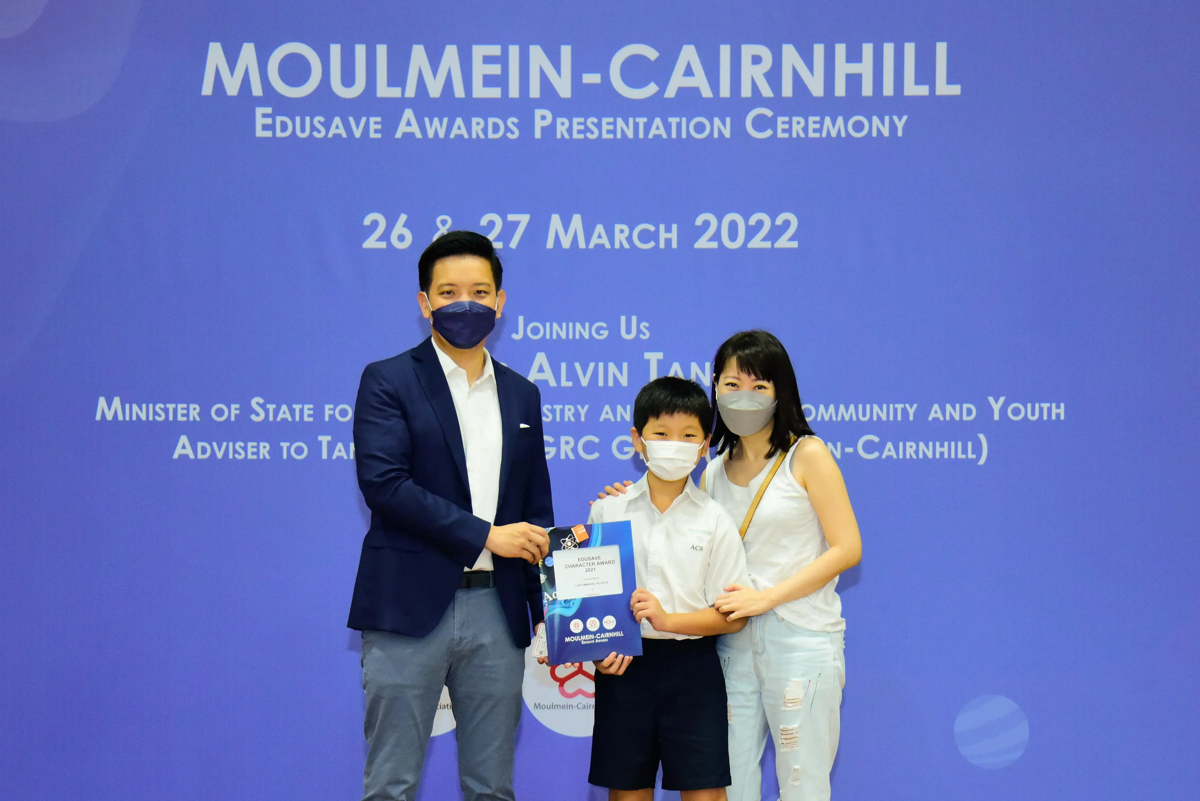 Three masked people pose at the Moulmein-Cairnhill Edusave Awards Ceremony on 26-27 March 2022.