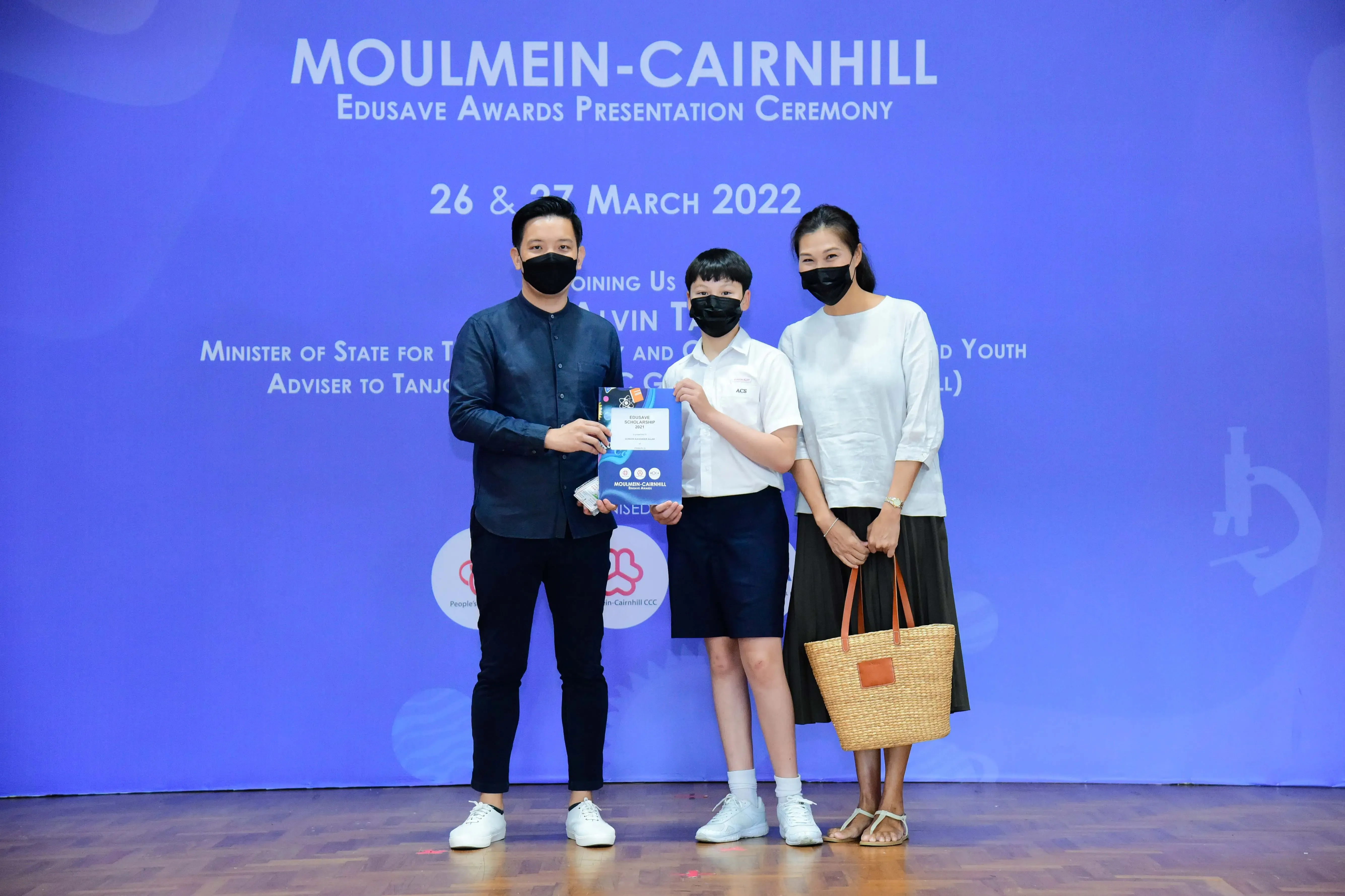 Three masked people pose at the Moulmein-Cairnhill Edusave Awards Presentation Ceremony on 26 & 27 March 2022.