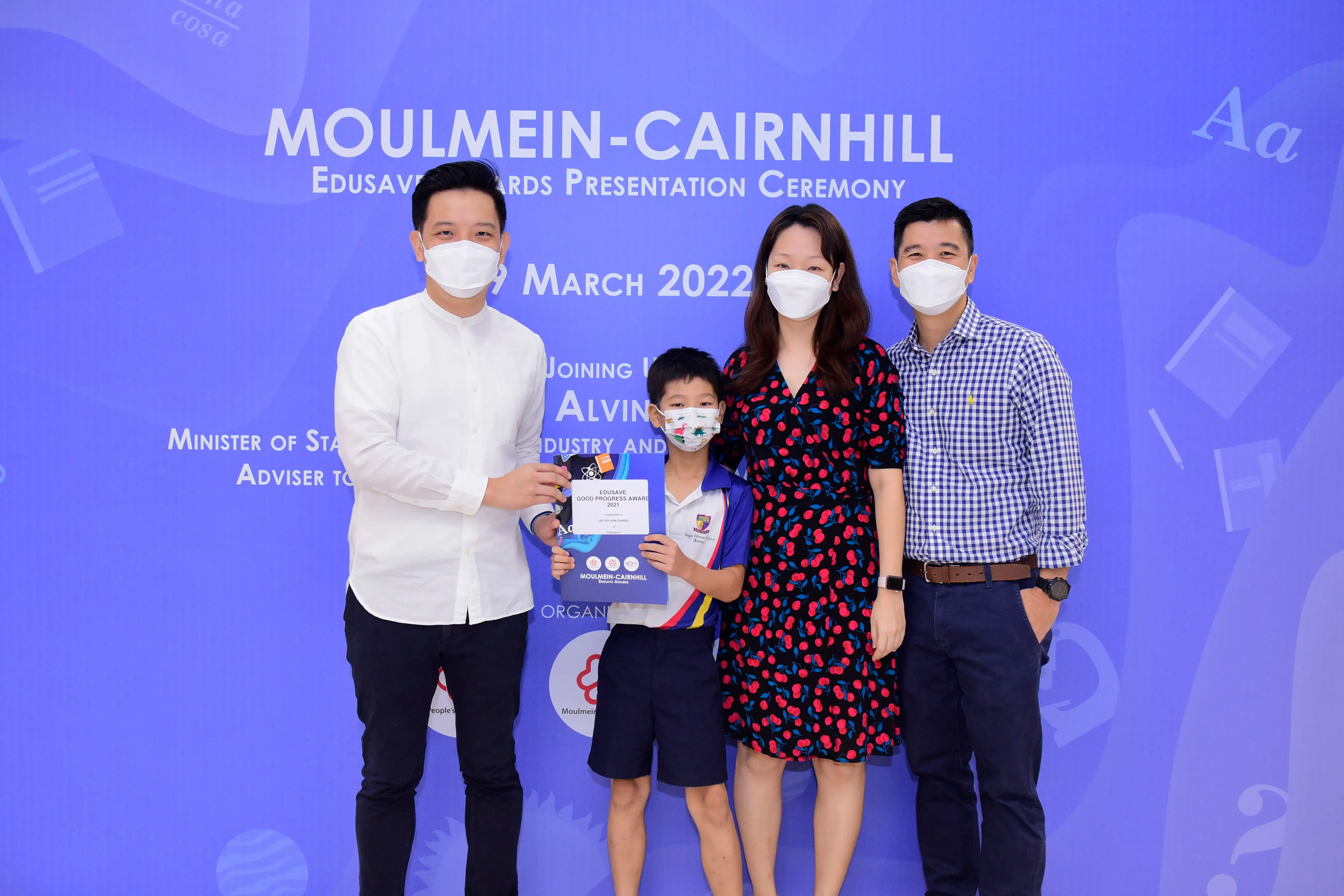 Four masked people pose at the Moulmein-Cairnhill Edusave Awards Presentation Ceremony on 19 March 2022.
