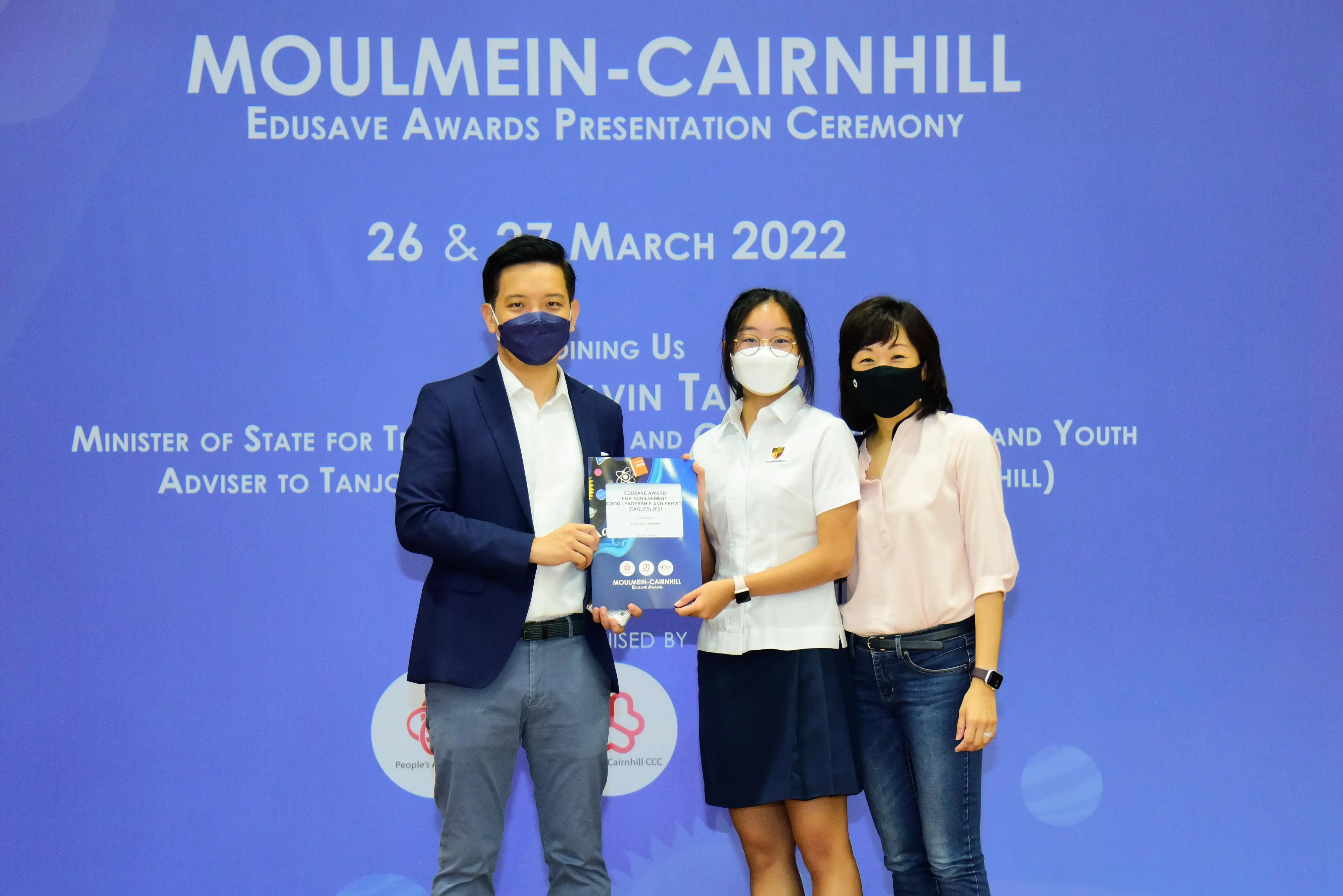 Three masked people pose at the Moulmein-Cairnhill Edusave Awards Presentation Ceremony on 26-27 March 2022.