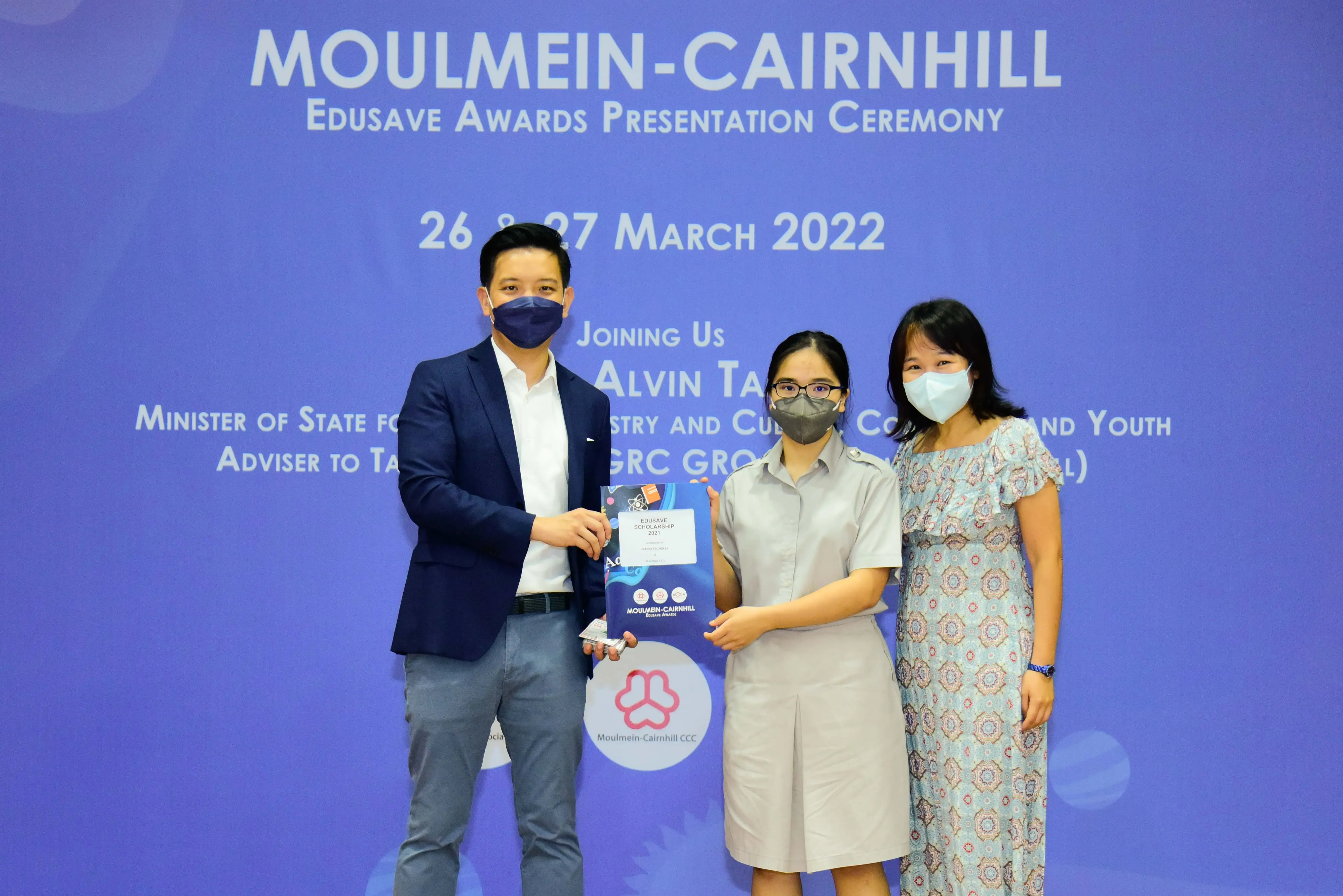Three masked people pose at the Moulmein-Cairnhill Edusave Awards Presentation Ceremony on 26-27 March 2022.