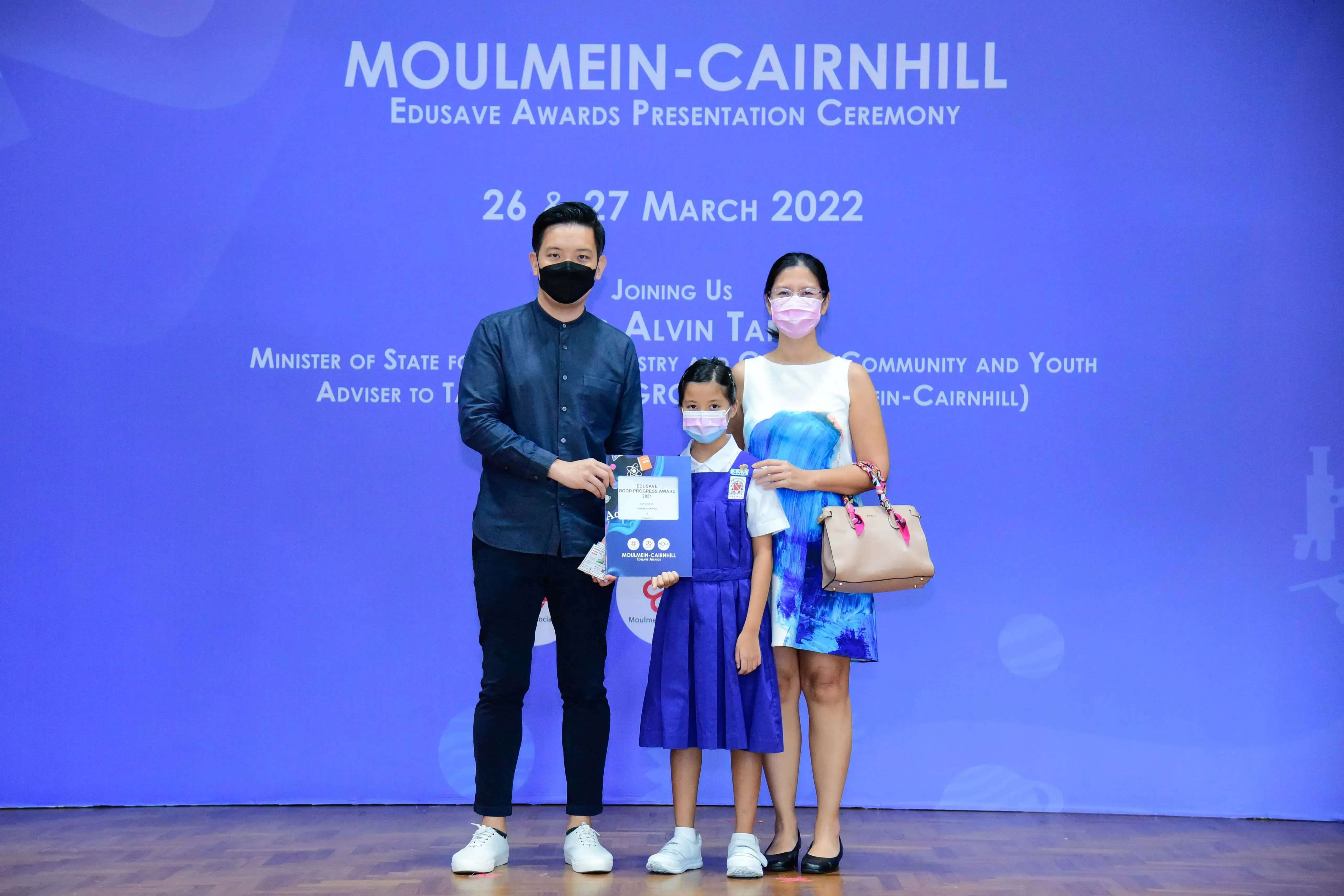 Three masked people pose at the Moulmein-Cairnhill Edusave Awards Presentation Ceremony on 26-27 March 2022.
