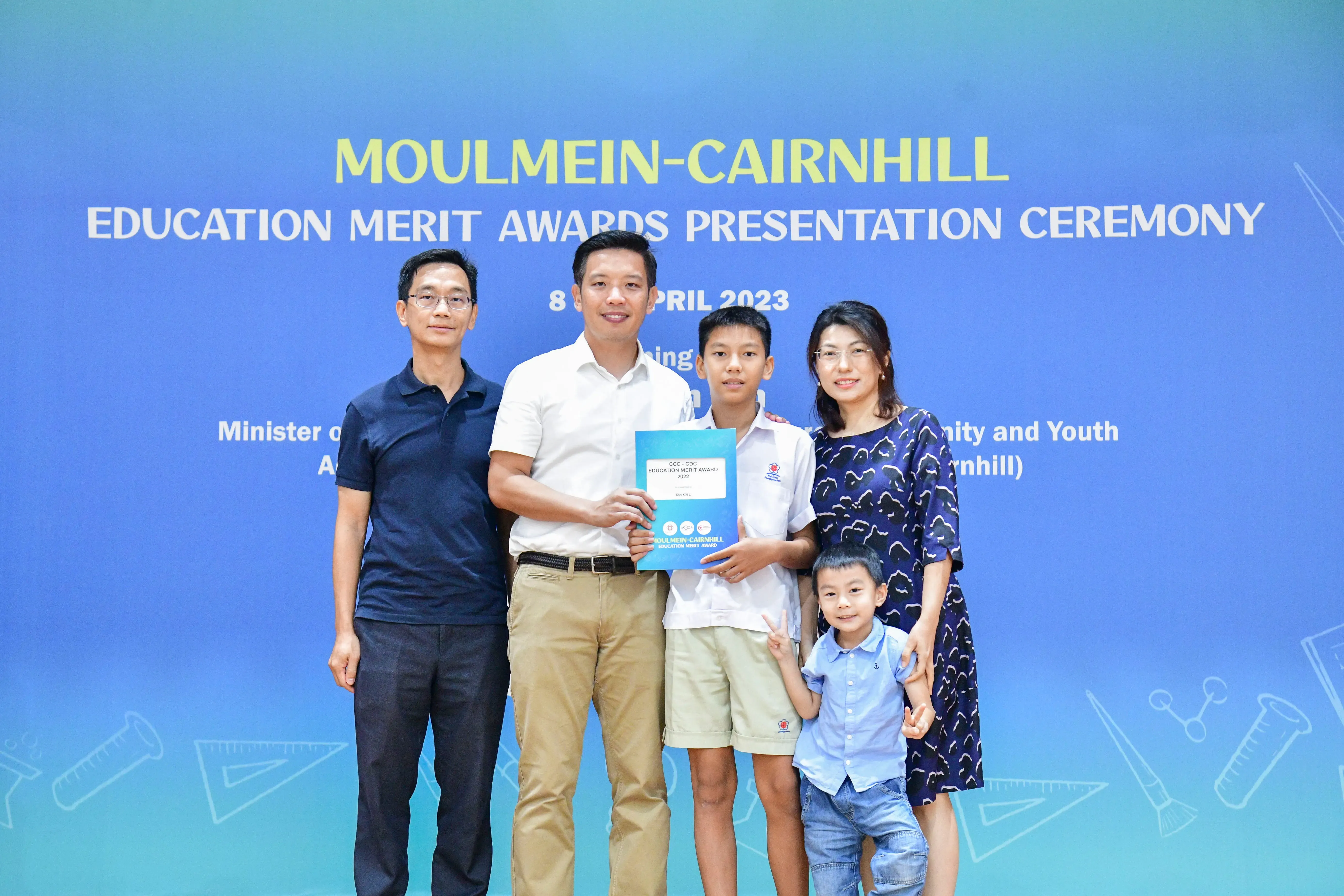 Five people pose with an award certificate at the Moulmein-Cairnhill Education Merit Awards Ceremony, April 2023.