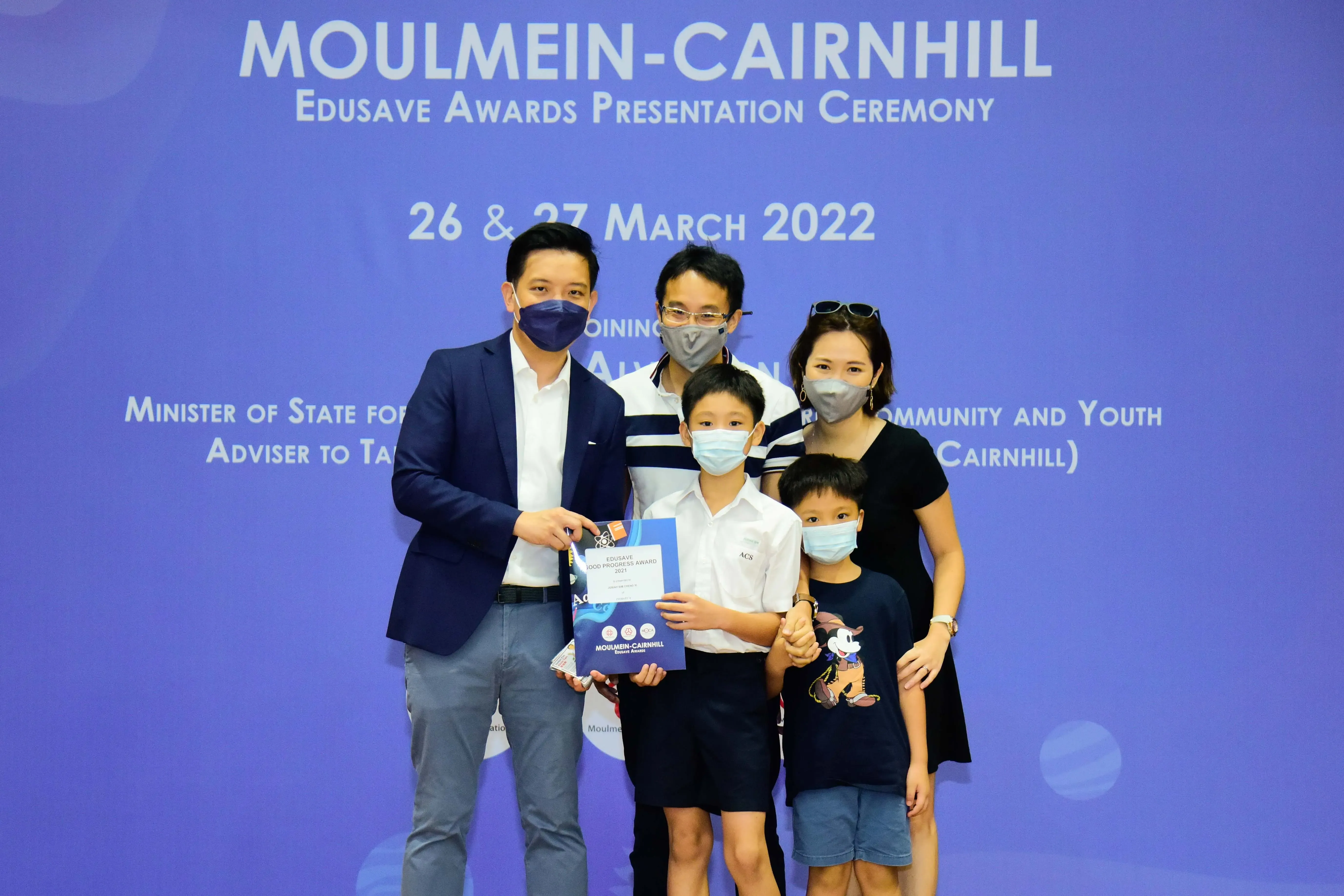Five masked people pose at the Moulmein-Cairnhill Edusave Awards Presentation Ceremony on 26-27 March 2022.