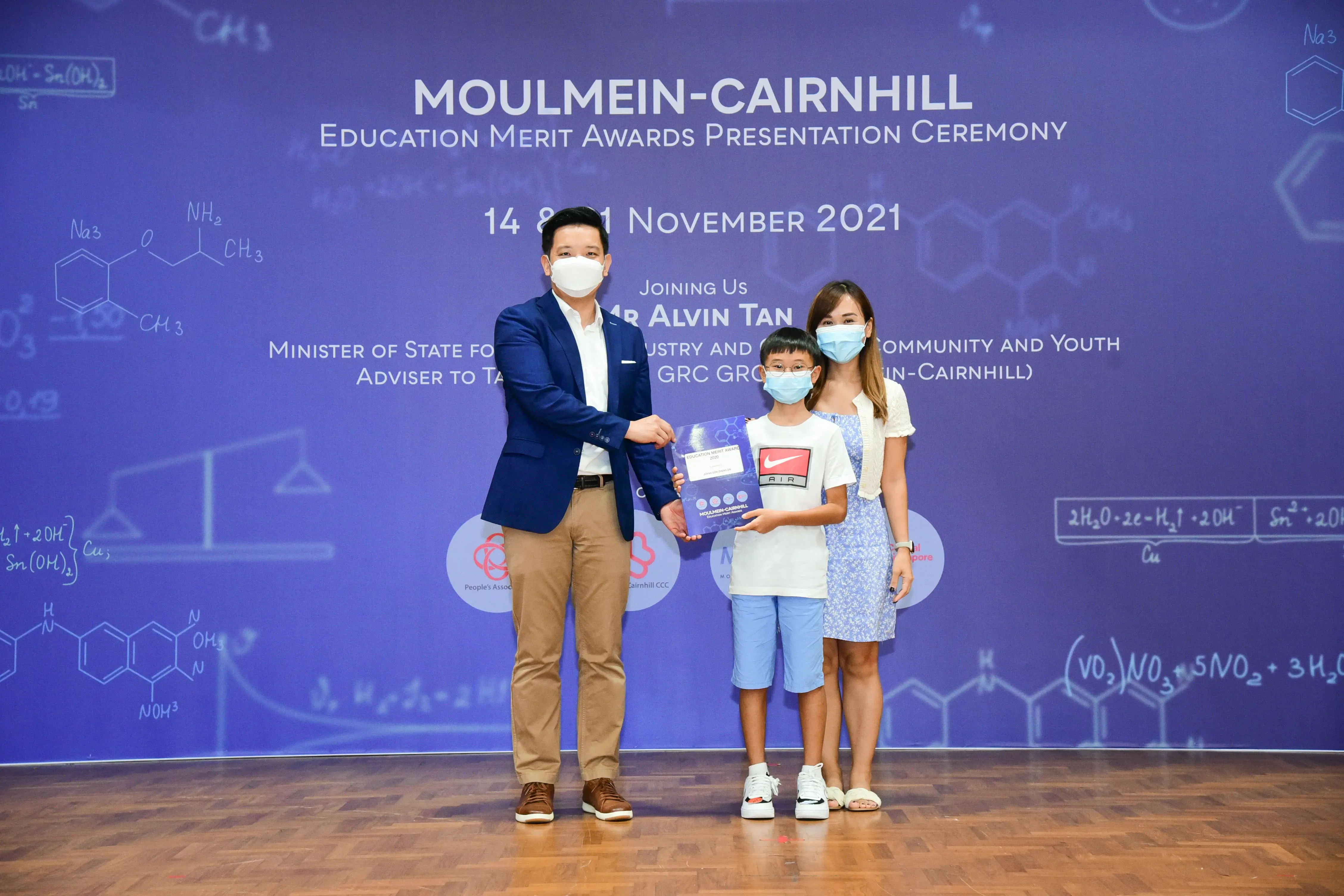 Three masked people pose at the Moulmein-Cairnhill Education Merit Awards Presentation Ceremony, November 2021.