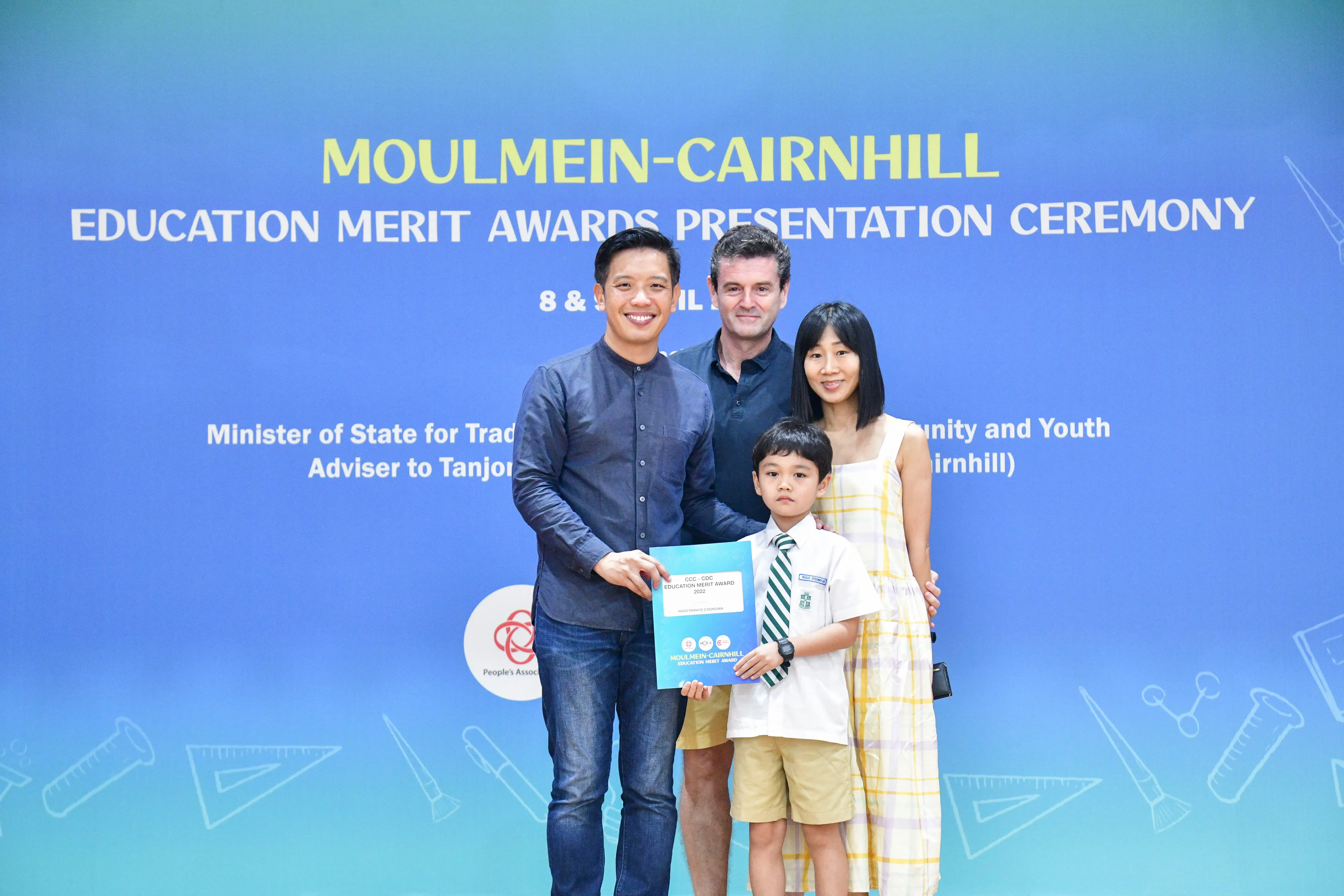 Four people pose with an award certificate at the Moulmein-Cairnhill Education Merit Awards Presentation Ceremony.