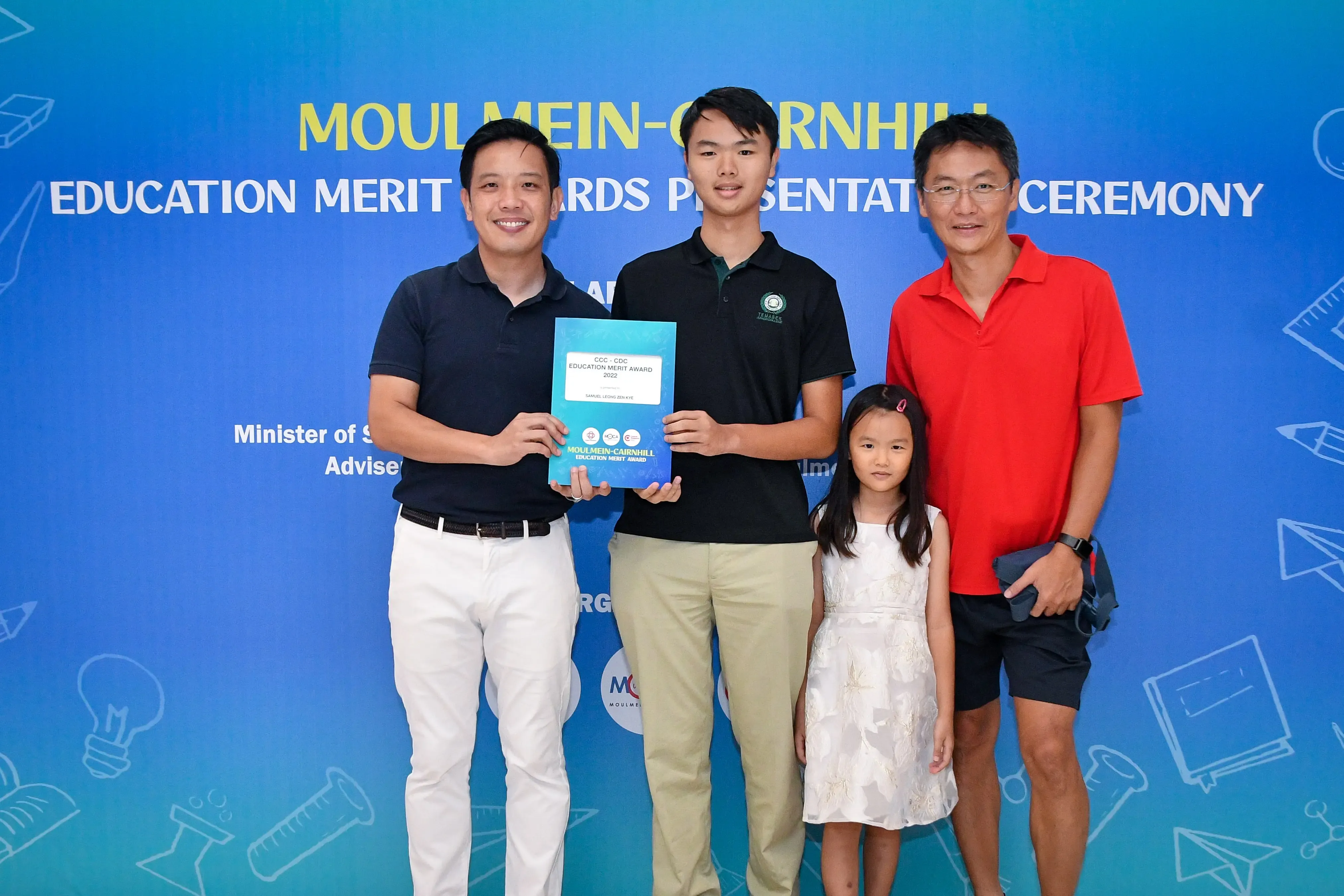 Four people pose holding a certificate at the Moulmein-Cairnhill Education Merit Awards Presentation Ceremony.