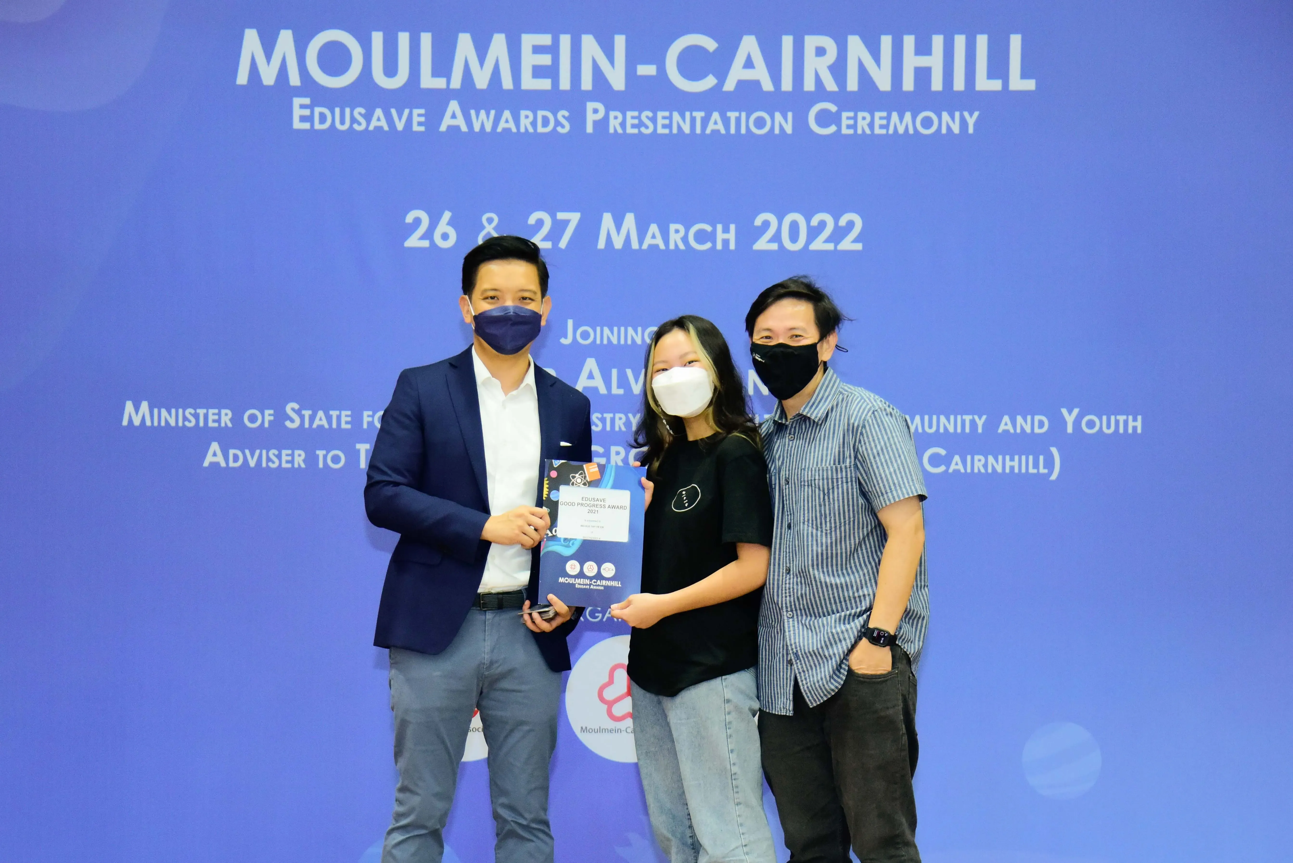 Three masked people pose at the Moulmein-Cairnhill Edusave Awards Presentation Ceremony on 26-27 March 2022.