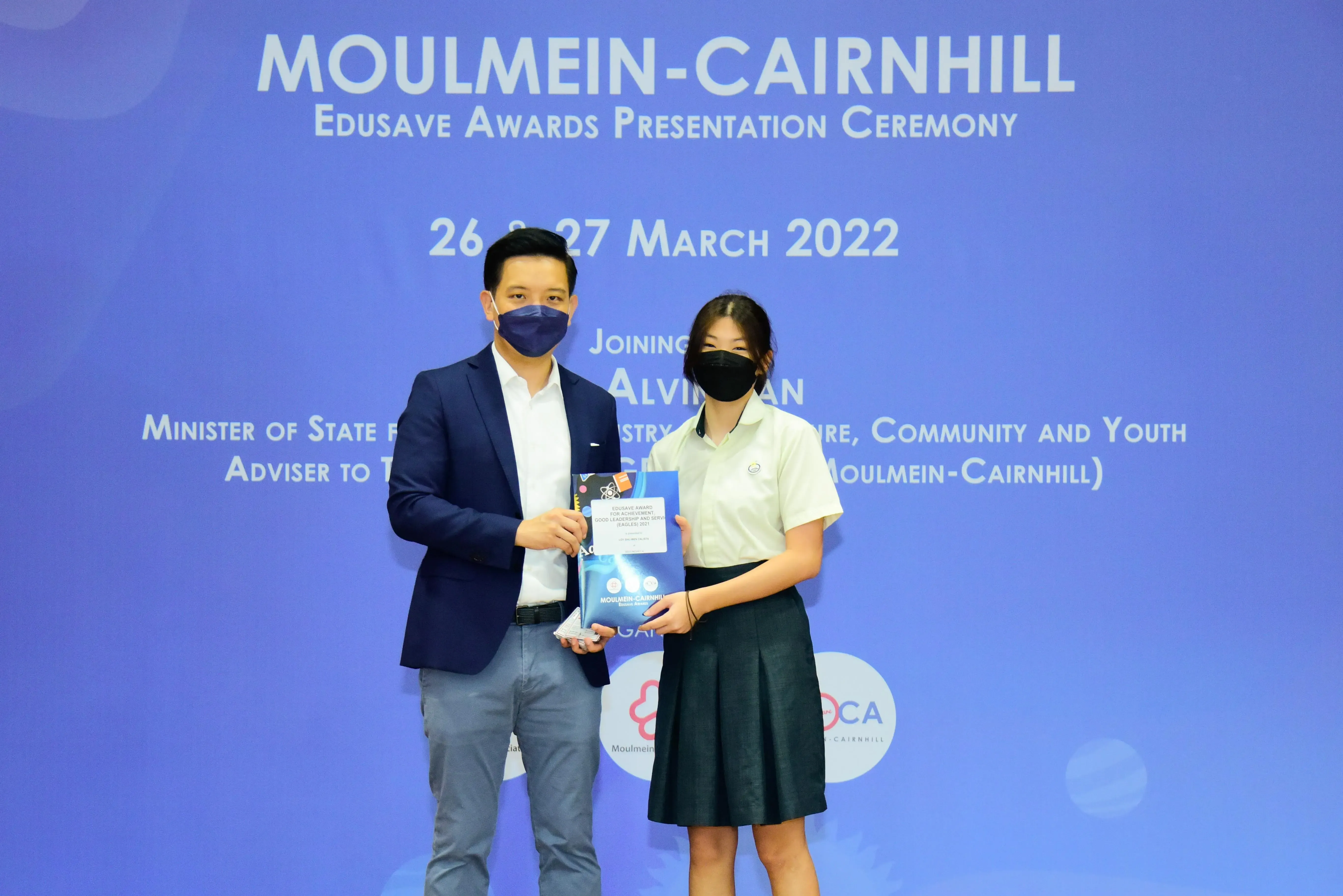 Two masked individuals pose at the Moulmein-Cairnhill Edusave Awards Presentation Ceremony on 26-27 March 2022.