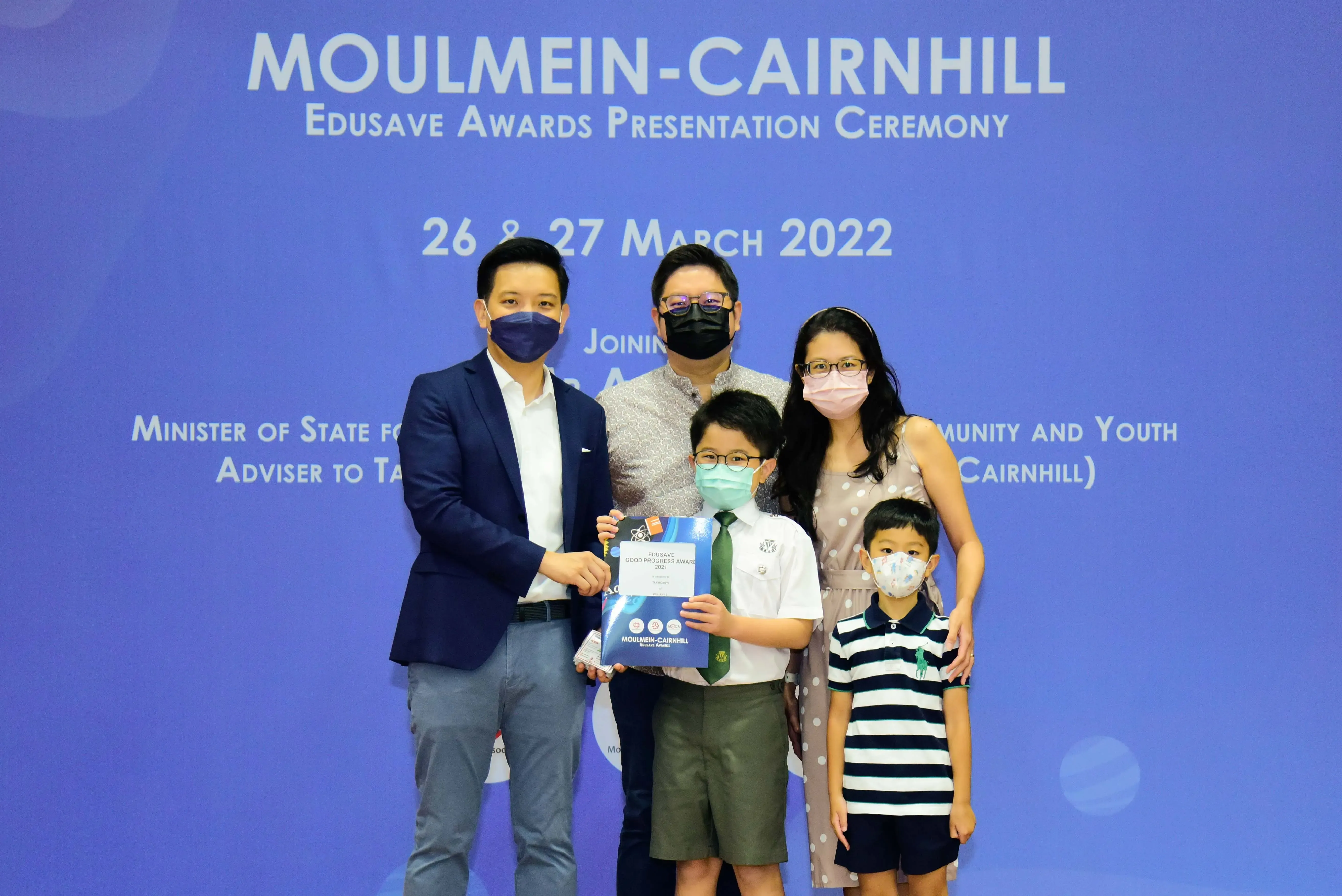 Five masked people pose at the Moulmein-Cairnhill Edusave Awards Presentation Ceremony on 26-27 March 2022.