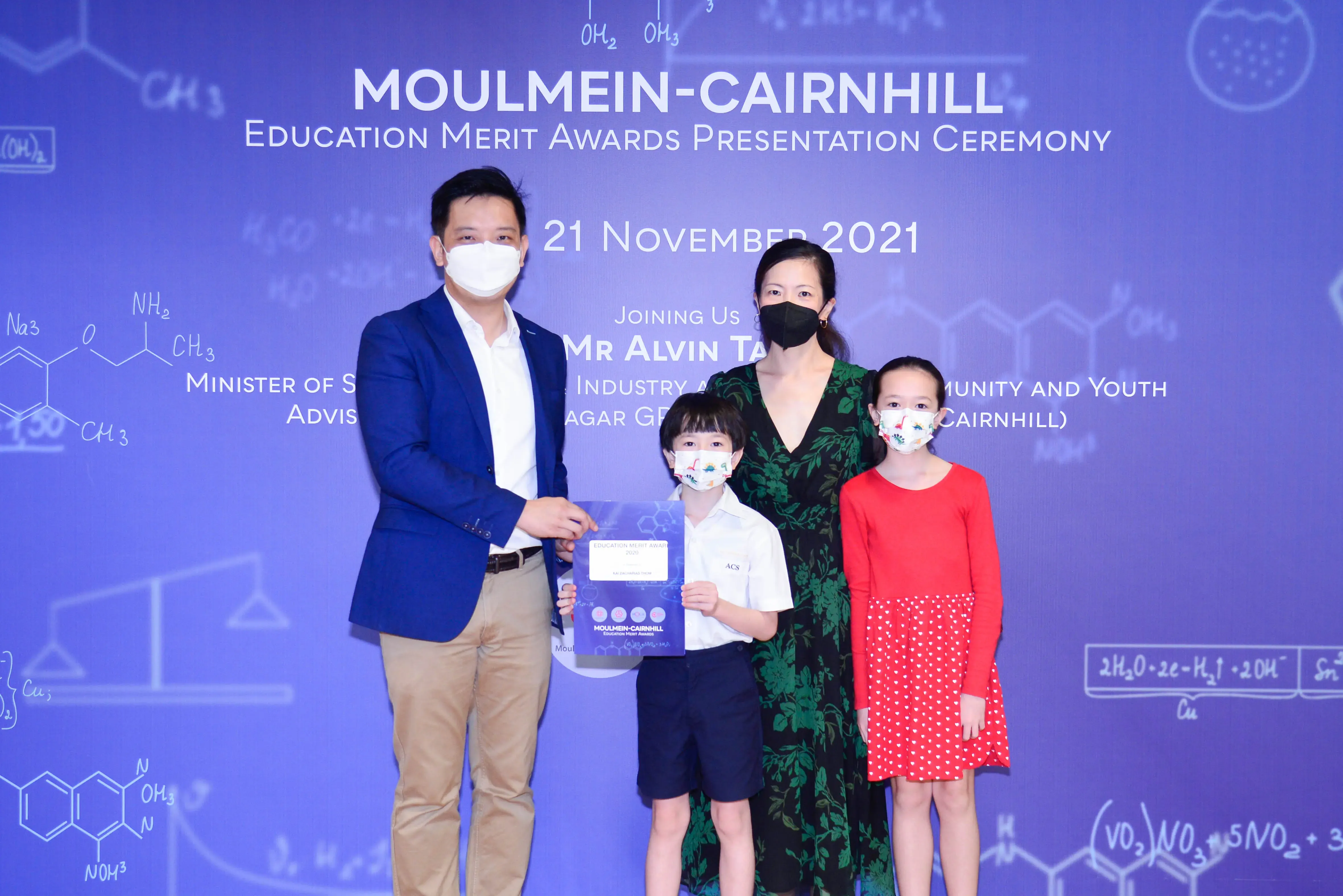 Four masked people pose at the Moulmein-Cairnhill Education Merit Awards Presentation Ceremony on 21 November 2021.