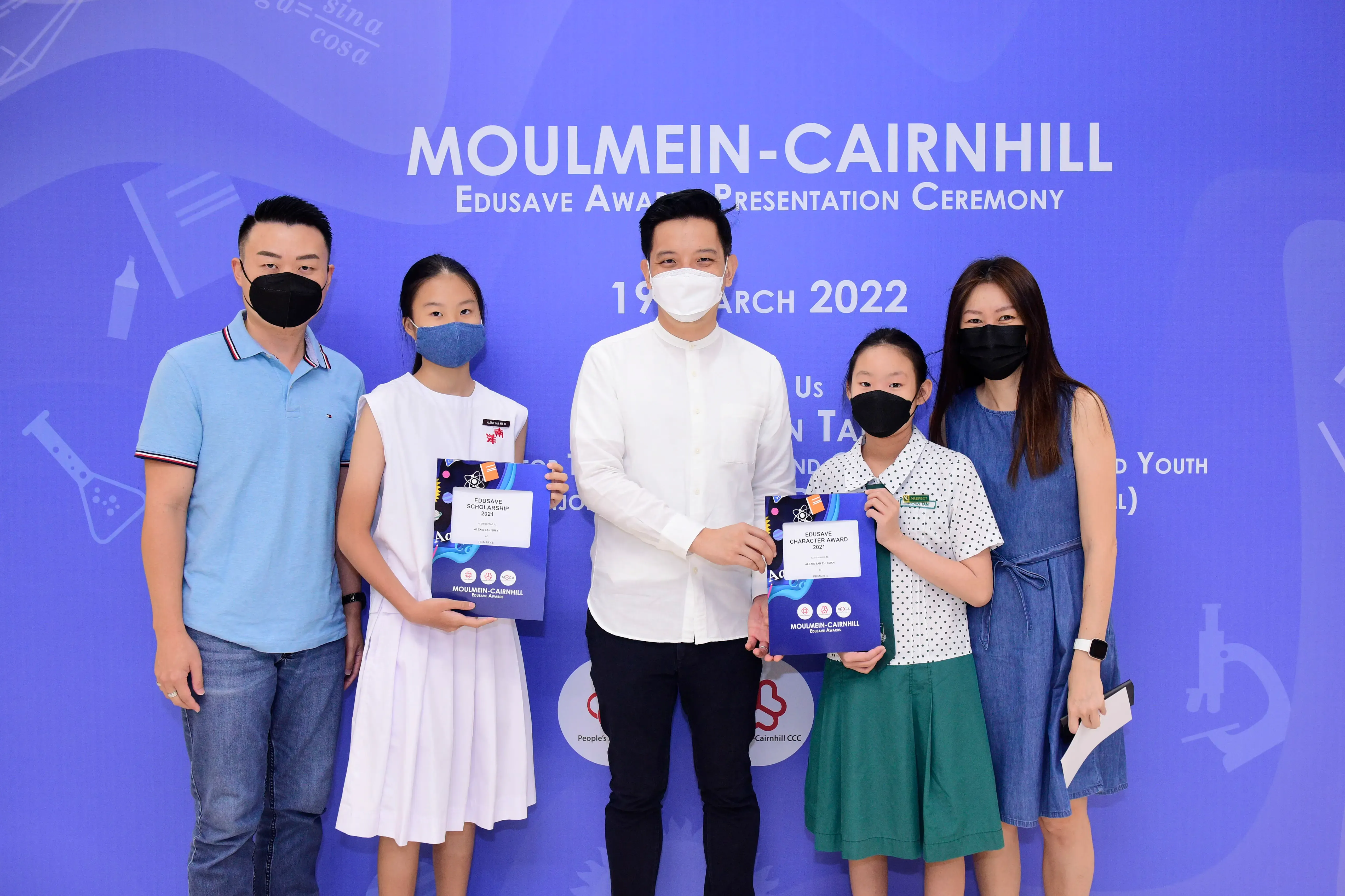 Five masked people pose at the Moulmein-Cairnhill Edusave Award Presentation Ceremony on 19 March 2022.