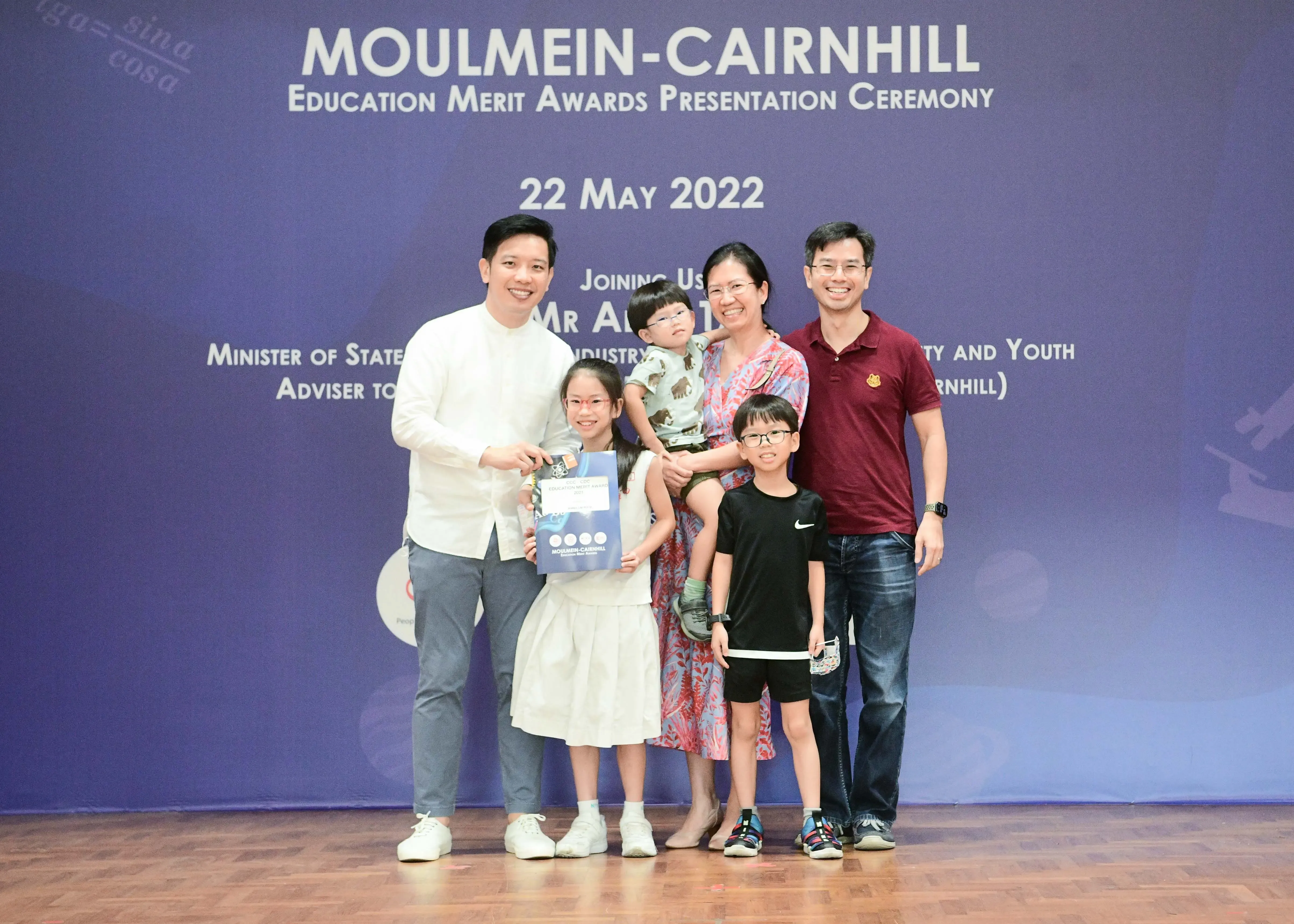 A family and an official pose at the Moulmein-Cairnhill Education Merit Awards Ceremony on 22 May 2022.