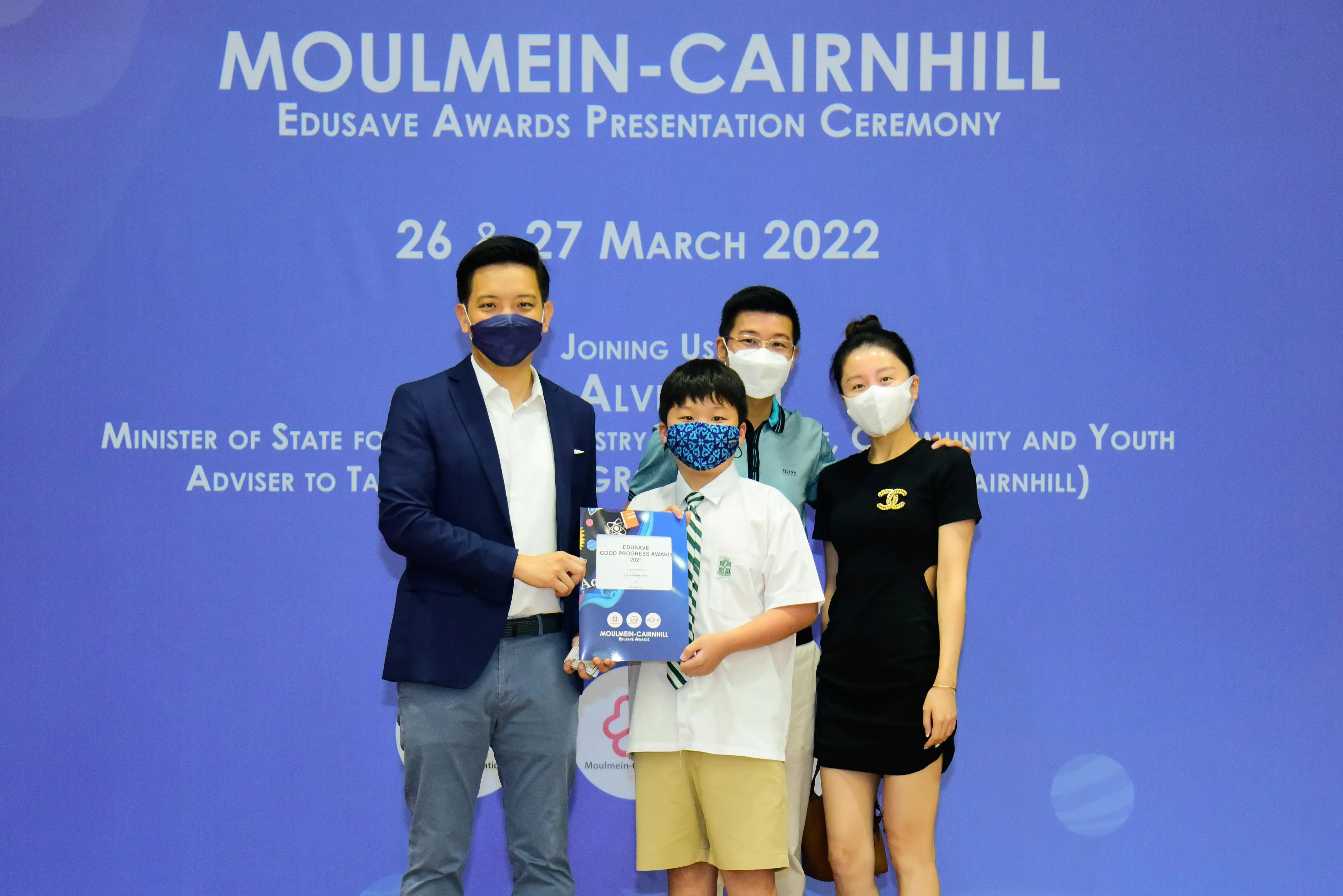 Four masked people pose at the Moulmein-Cairnhill Edusave Awards Presentation Ceremony on 26-27 March 2022.