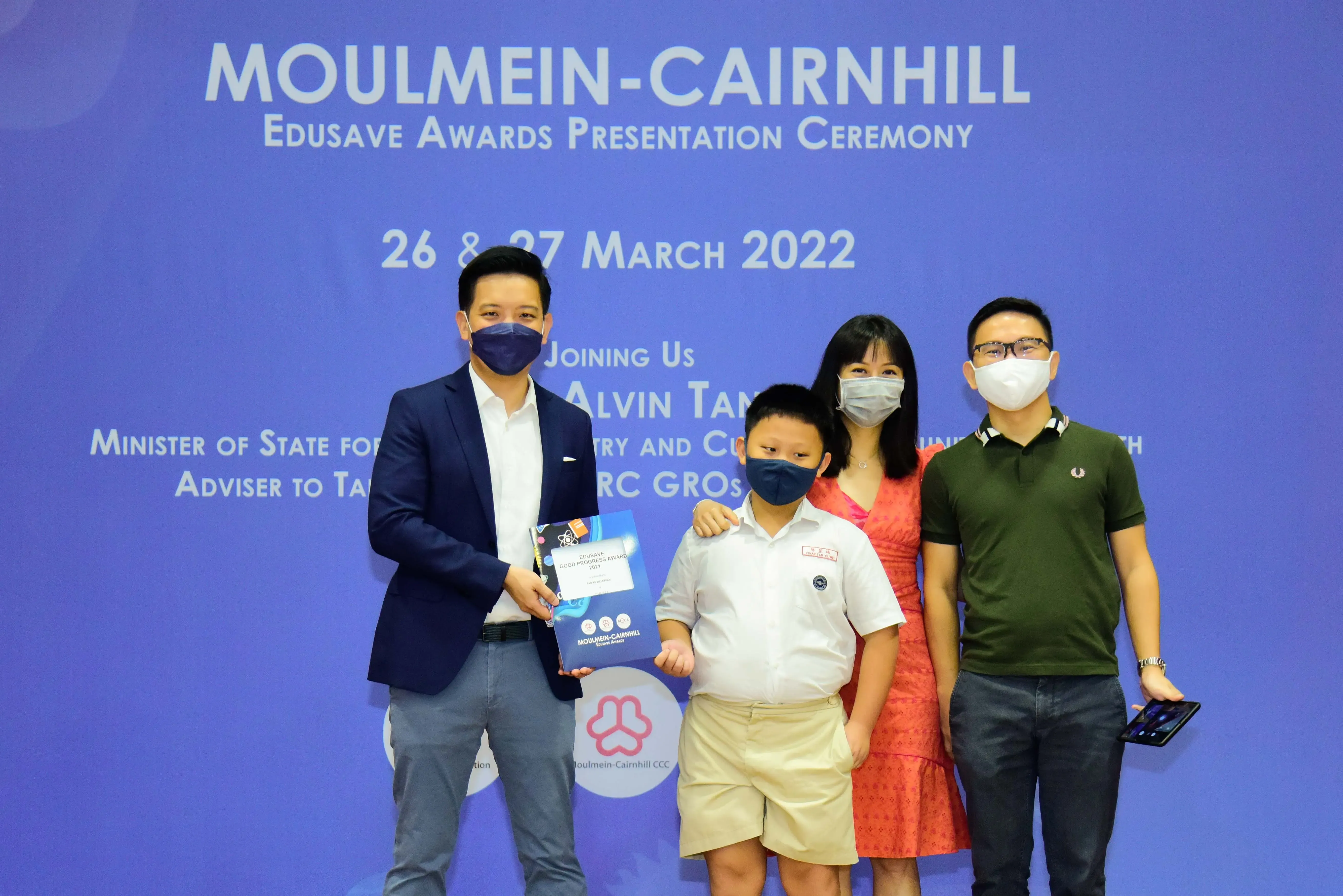 Four masked people pose at the Moulmein-Cairnhill Edusave Awards Presentation Ceremony on 26-27 March 2022.