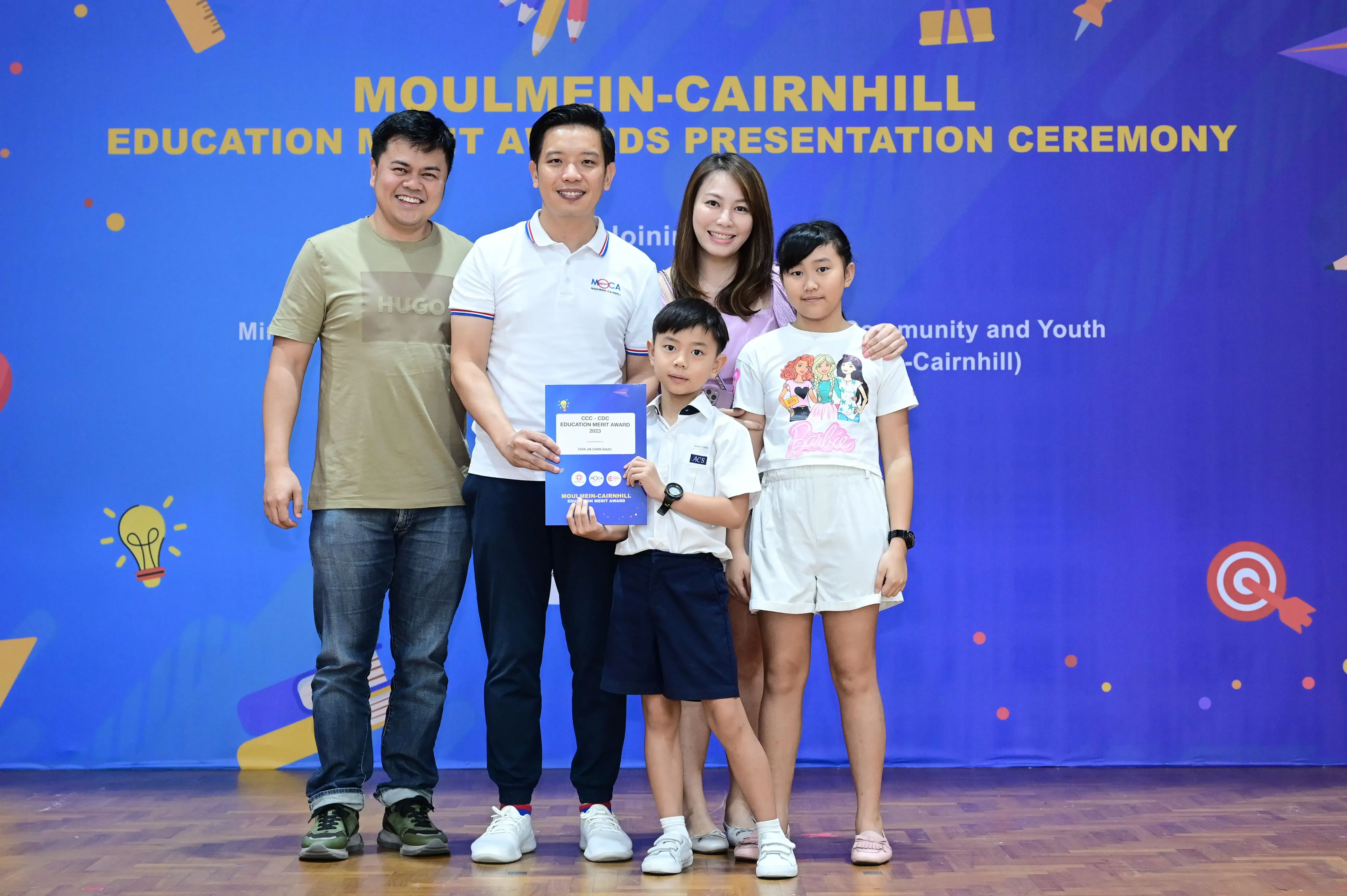 Five people pose with a certificate at the Moulmein-Cairnhill Education Merit Awards Presentation Ceremony.