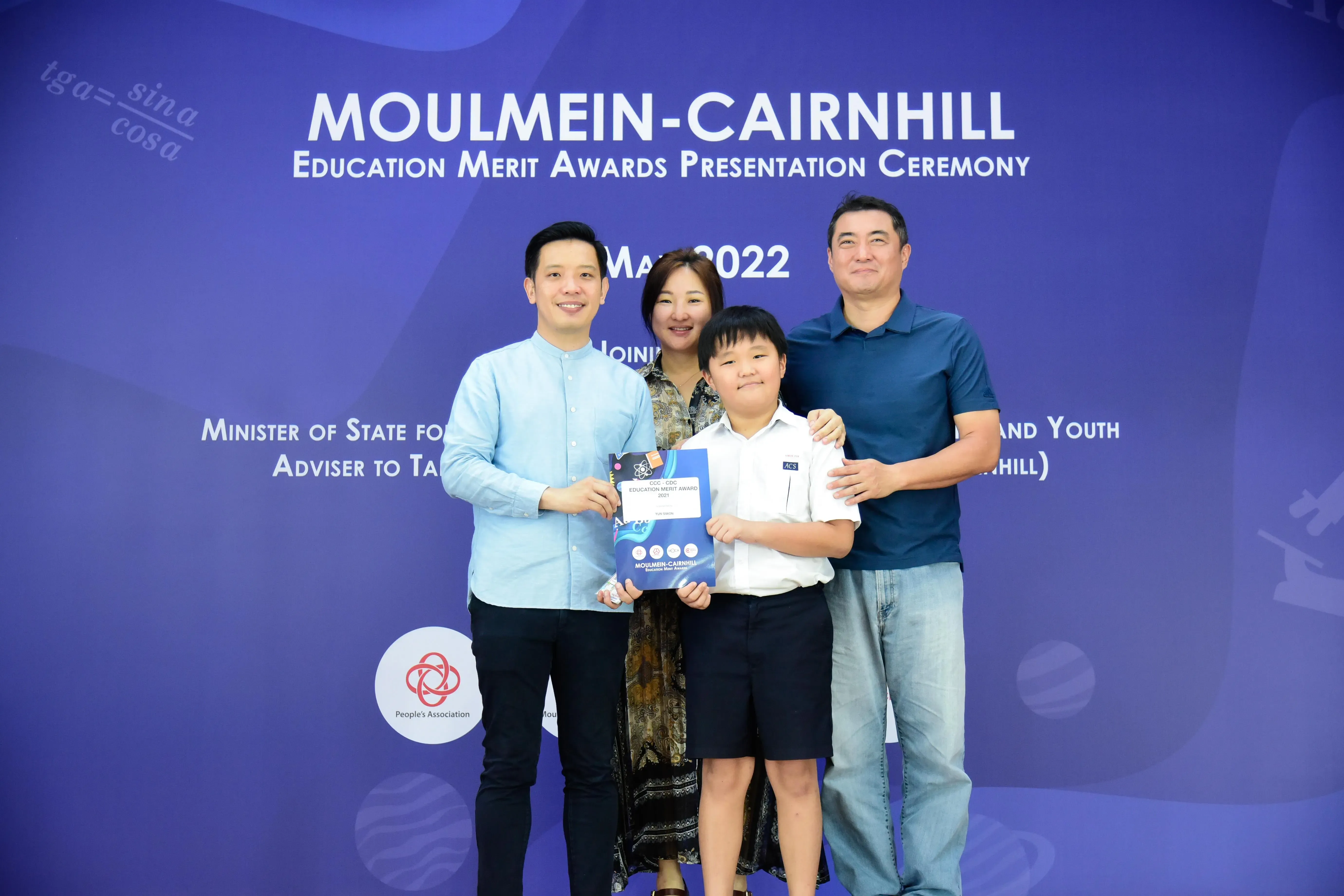 Three adults and a child pose at the Moulmein-Cairnhill Education Merit Awards Ceremony, May 2022.