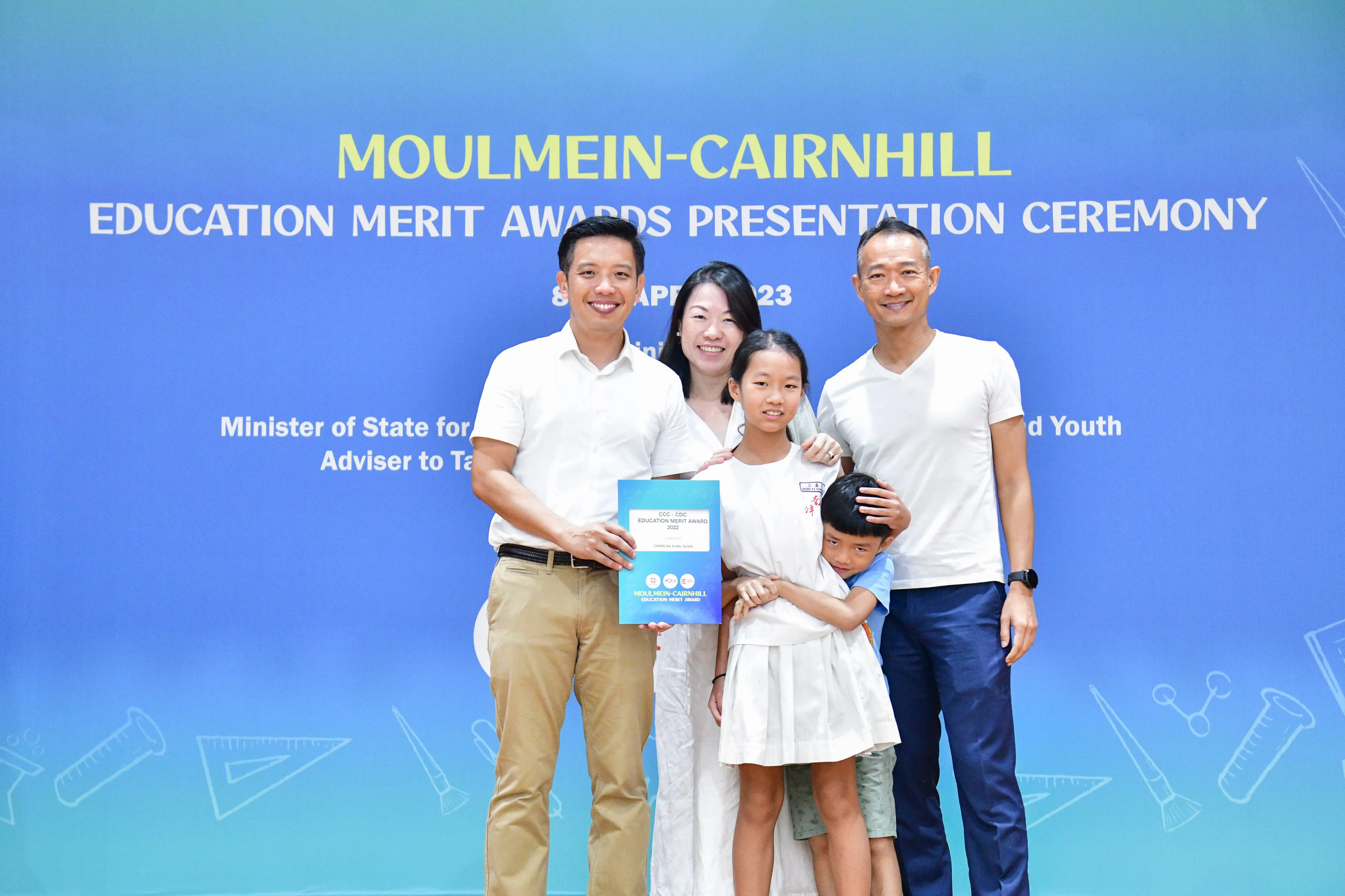 Five people pose with an award certificate at the Moulmein-Cairnhill Education Merit Awards Presentation Ceremony.