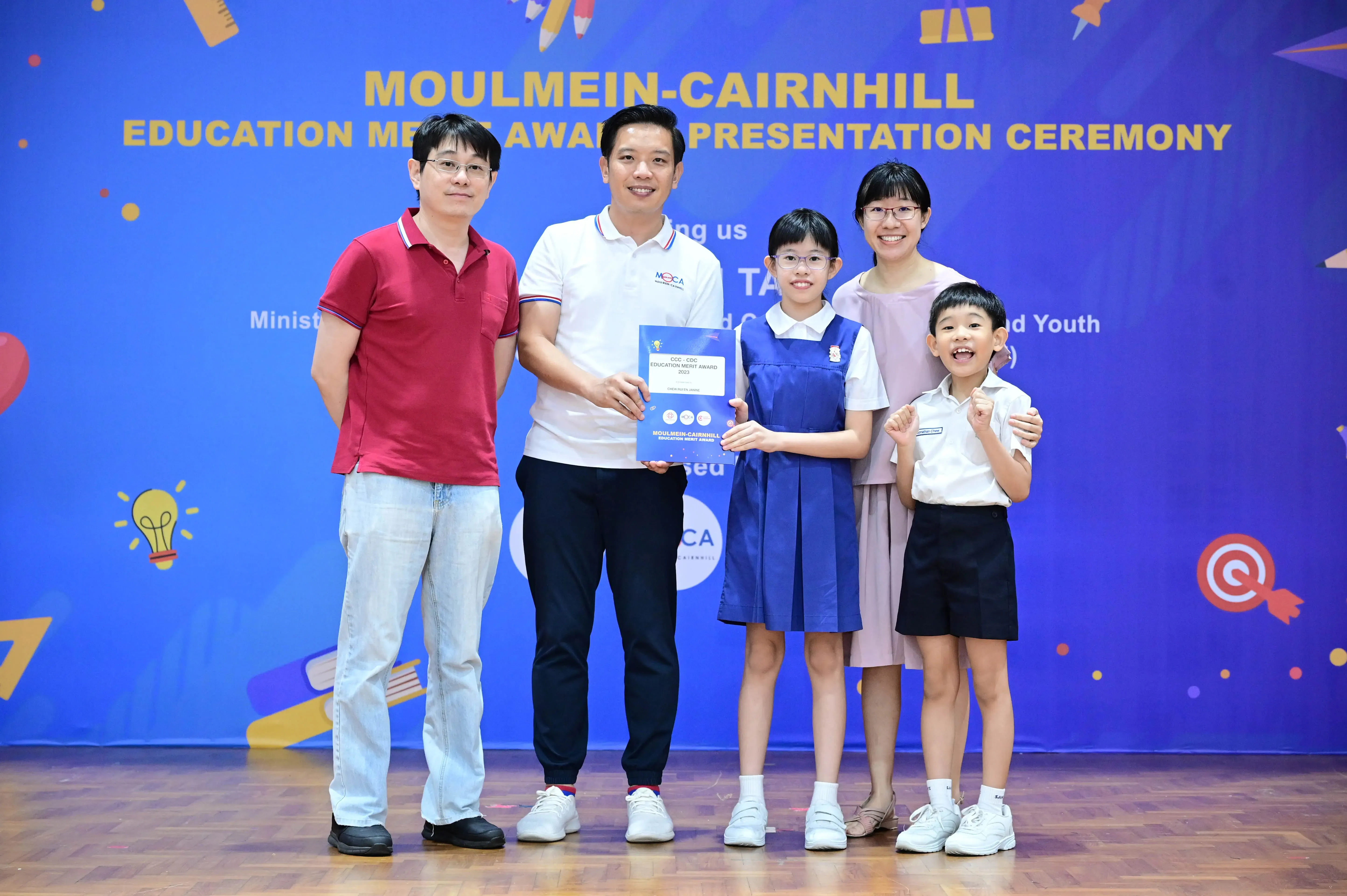 Five people pose at Moulmein-Cairnhill Education Merit Award Presentation Ceremony, holding an award certificate.
