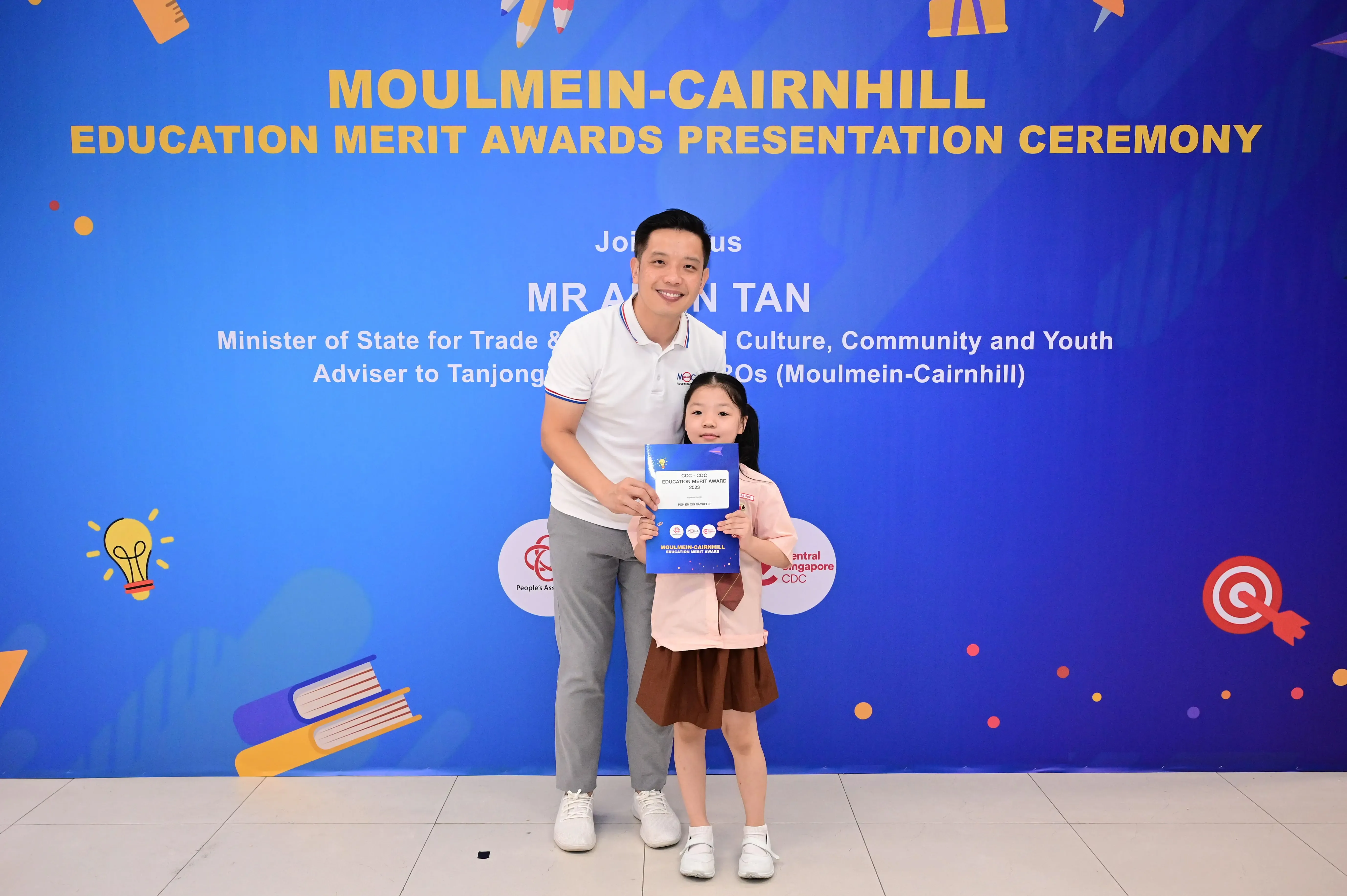 Man and young girl holding a certificate at the Moulmein-Cairnhill Education Merit Awards Presentation Ceremony.