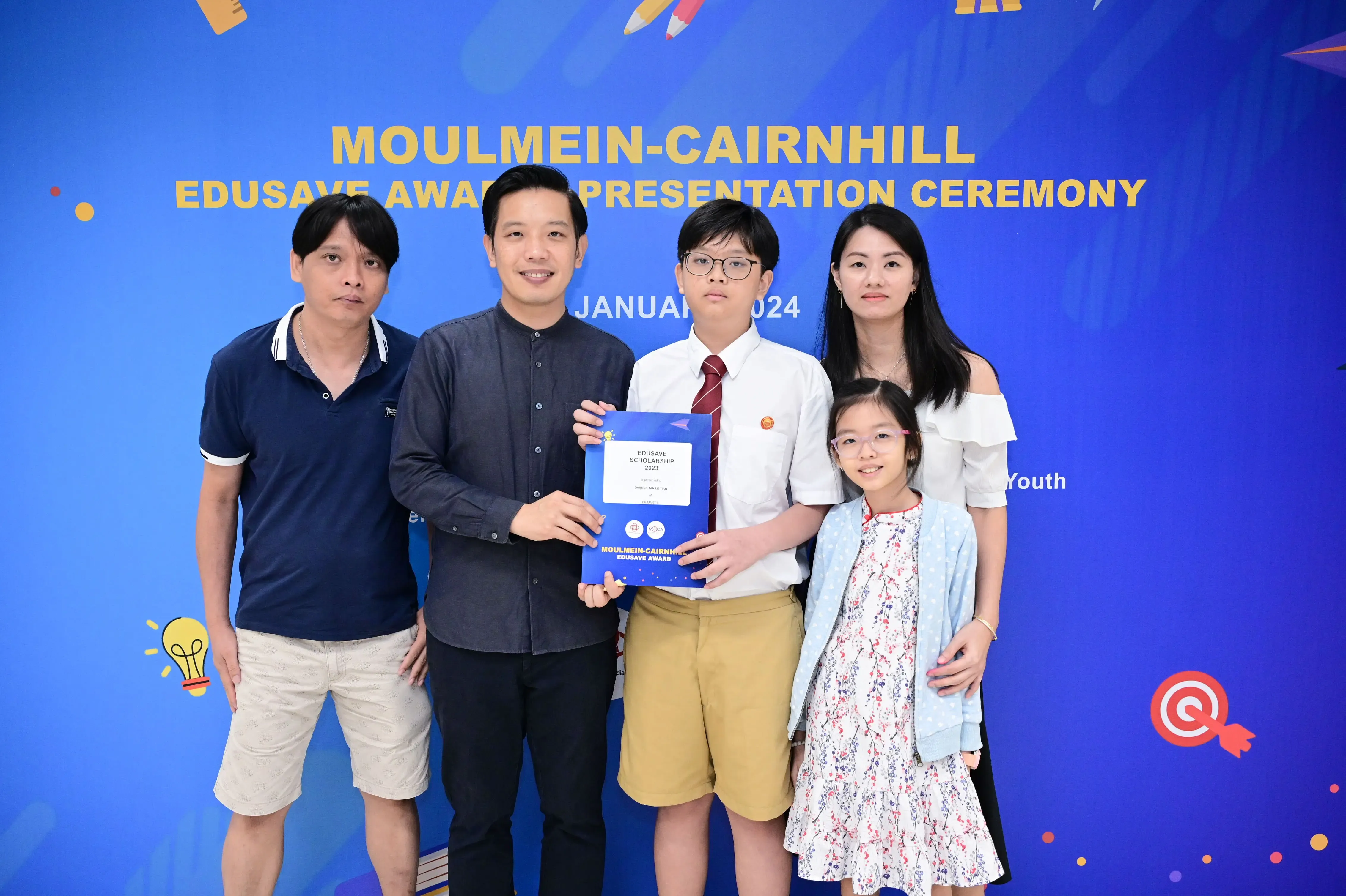 Five people pose with an Edusave Scholarship certificate at the Moulmein-Cairnhill Award Presentation Ceremony, January 2024.