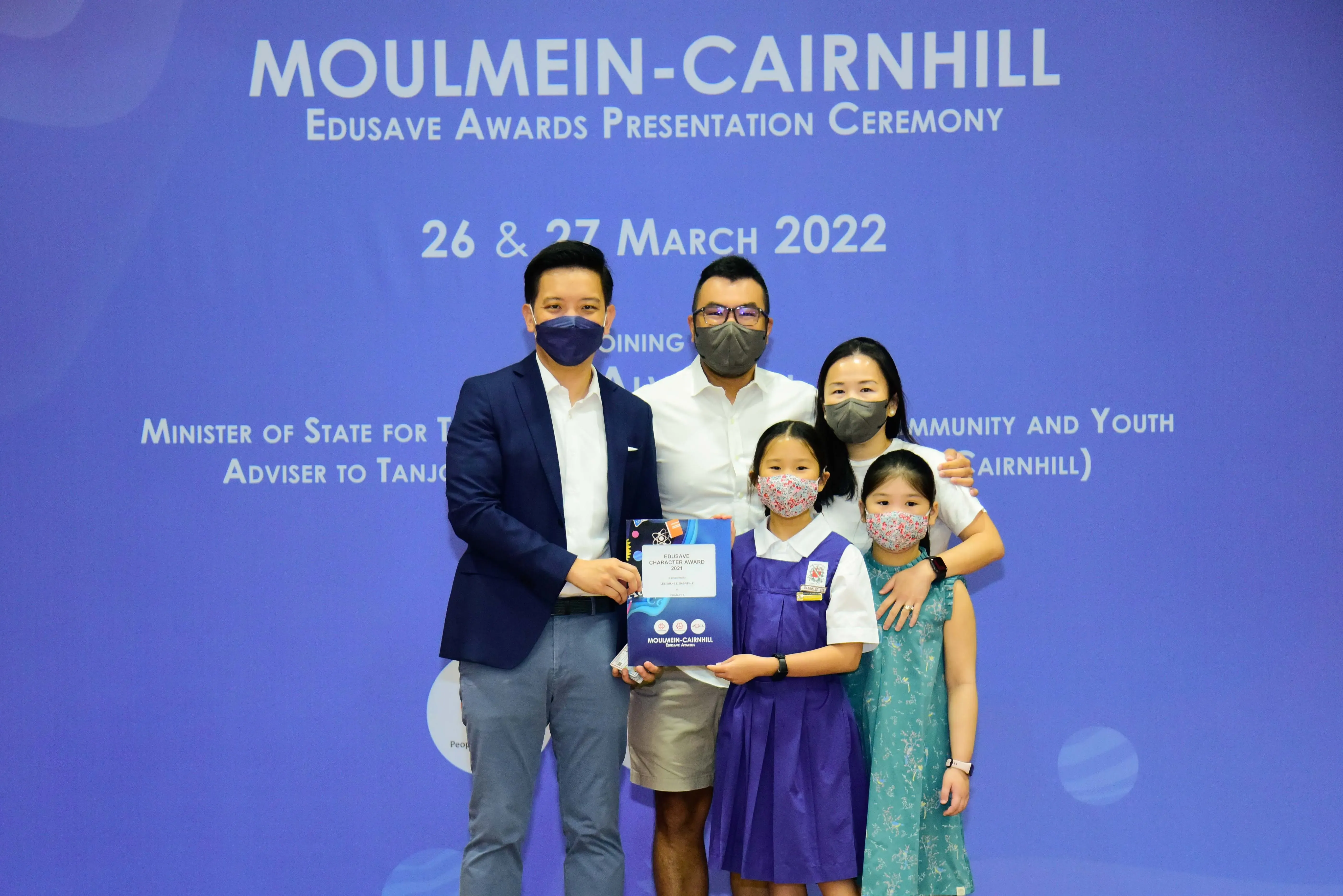 Five masked people pose at the Moulmein-Cairnhill Edusave Awards Presentation Ceremony on 26-27 March 2022.