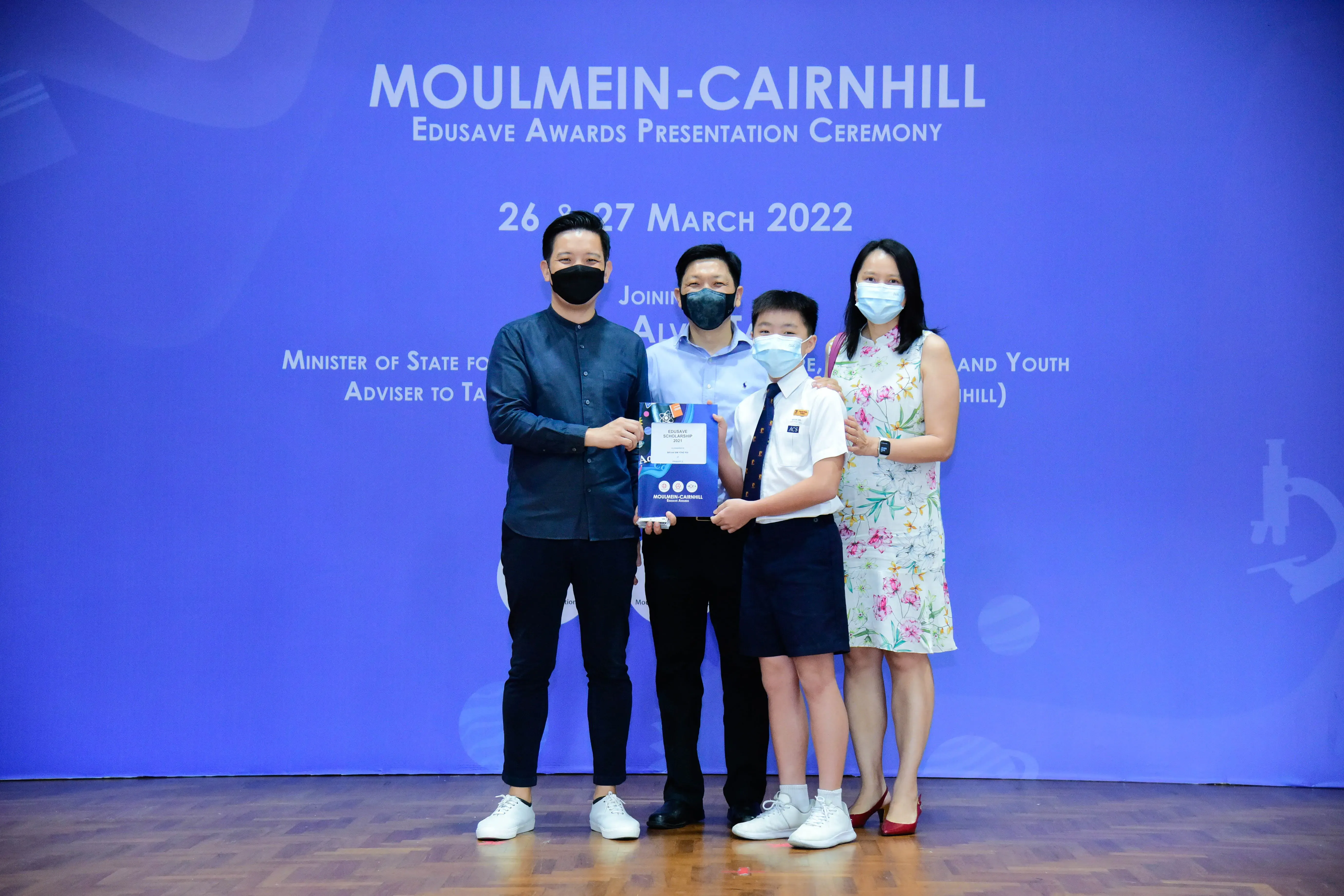 Four masked people pose at the Moulmein-Cairnhill Edusave Awards Presentation Ceremony on 26-27 March 2022.