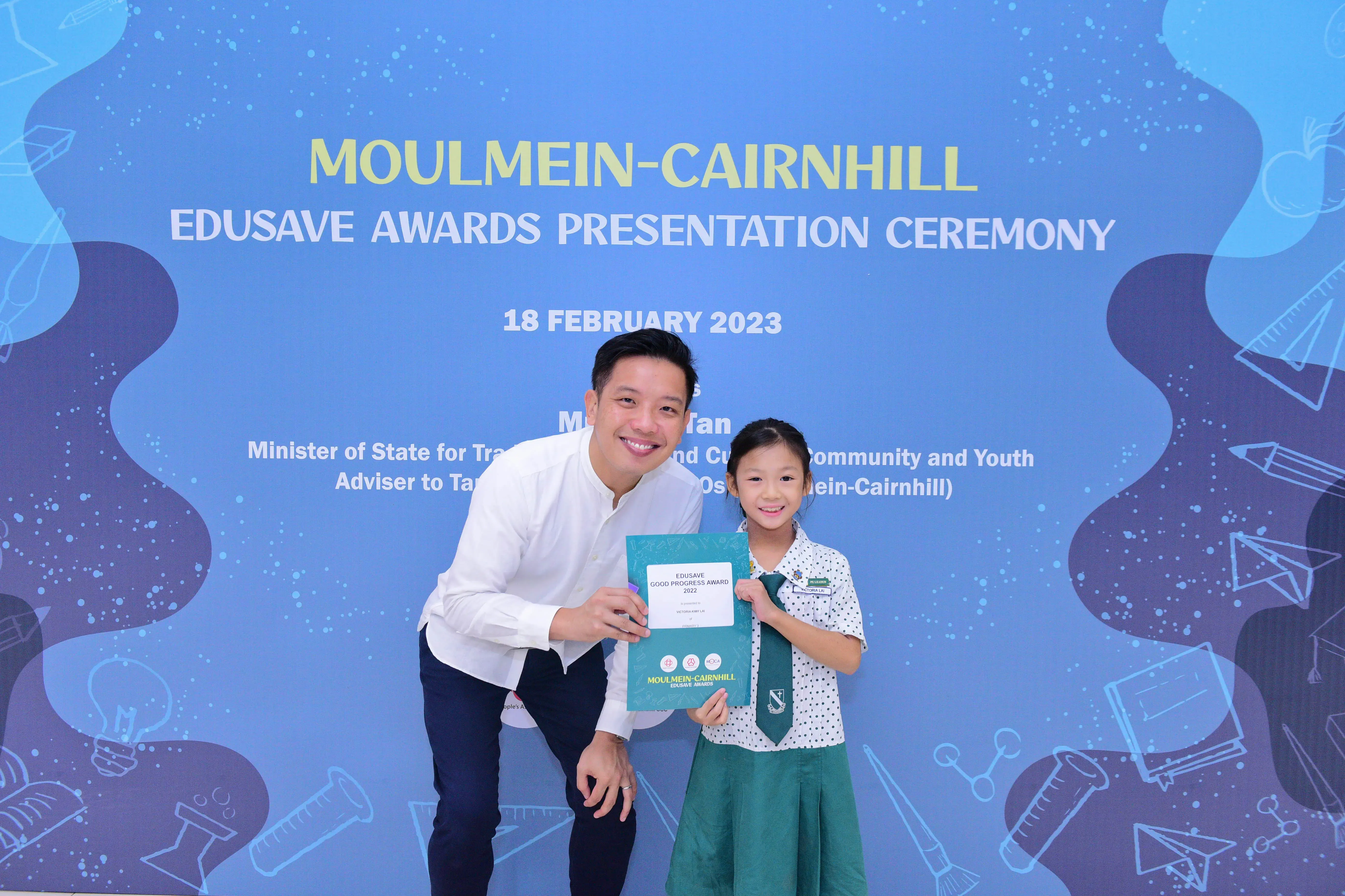 A man and a young girl hold an Edusave Good Progress Award certificate at the Moulmein-Cairnhill ceremony on 18 February 2023.