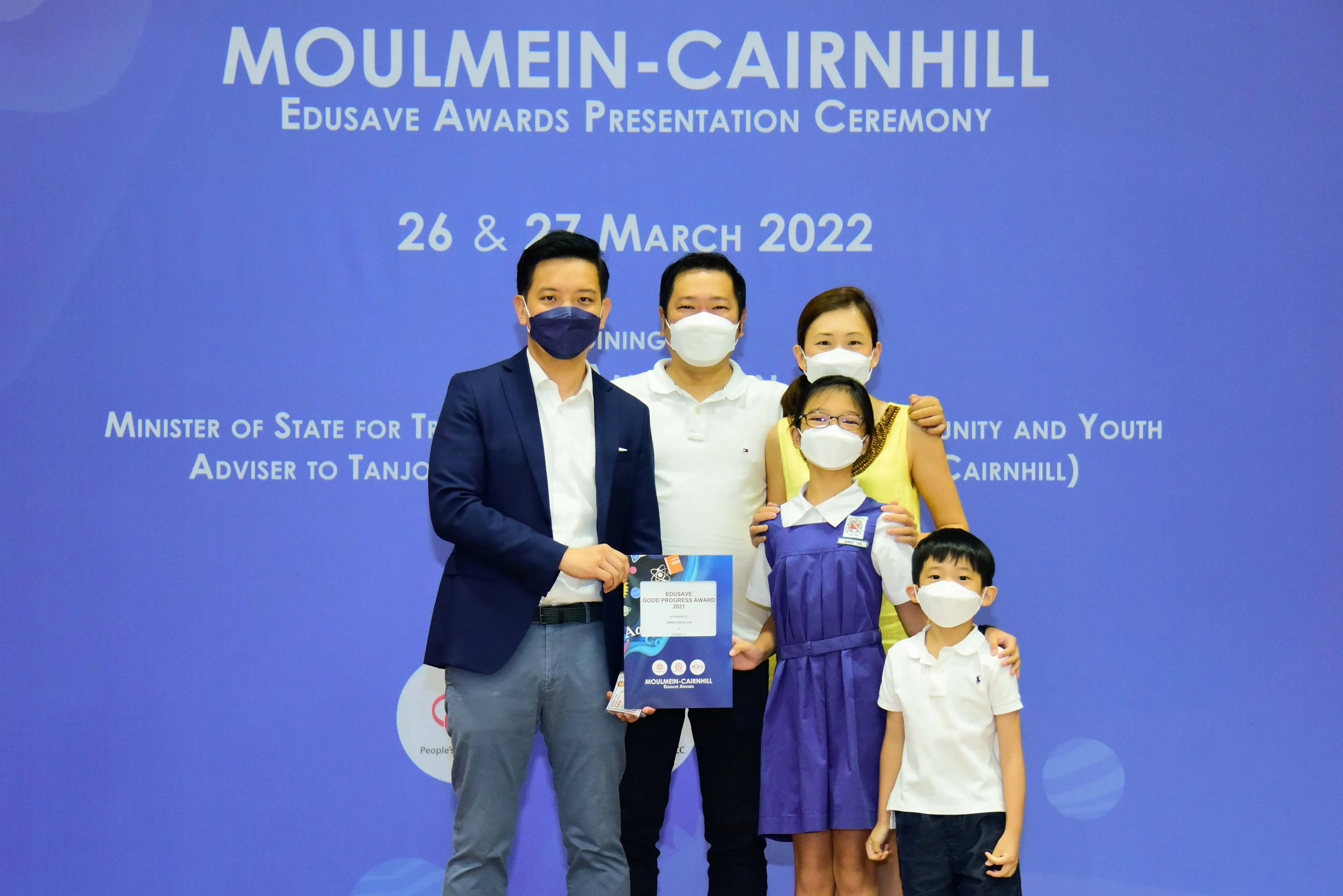 Five masked people pose at the Moulmein-Cairnhill Edusave Awards Presentation Ceremony on 26-27 March 2022.