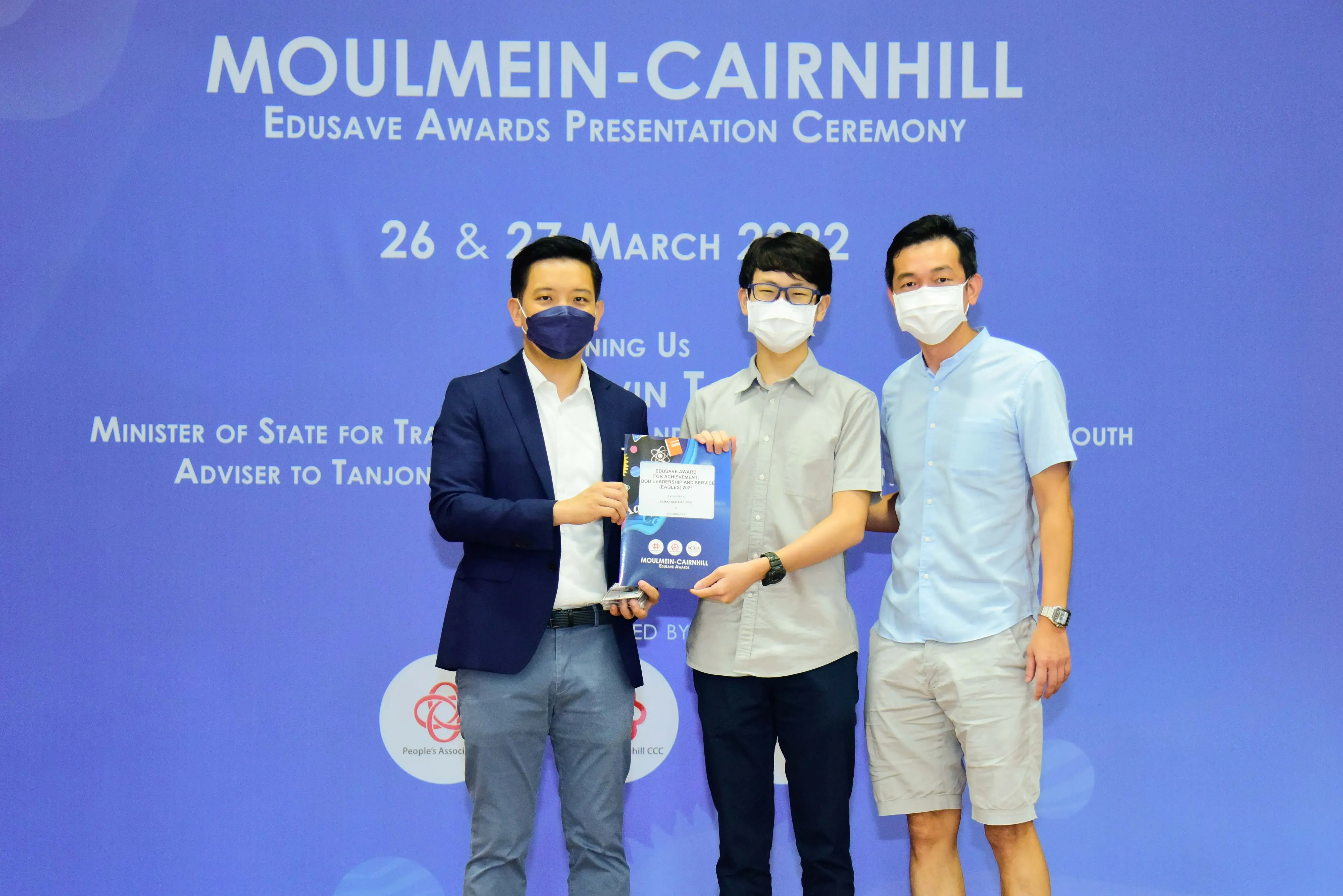 Three masked men pose at the Moulmein-Cairnhill Edusave Awards Presentation Ceremony, March 2022.