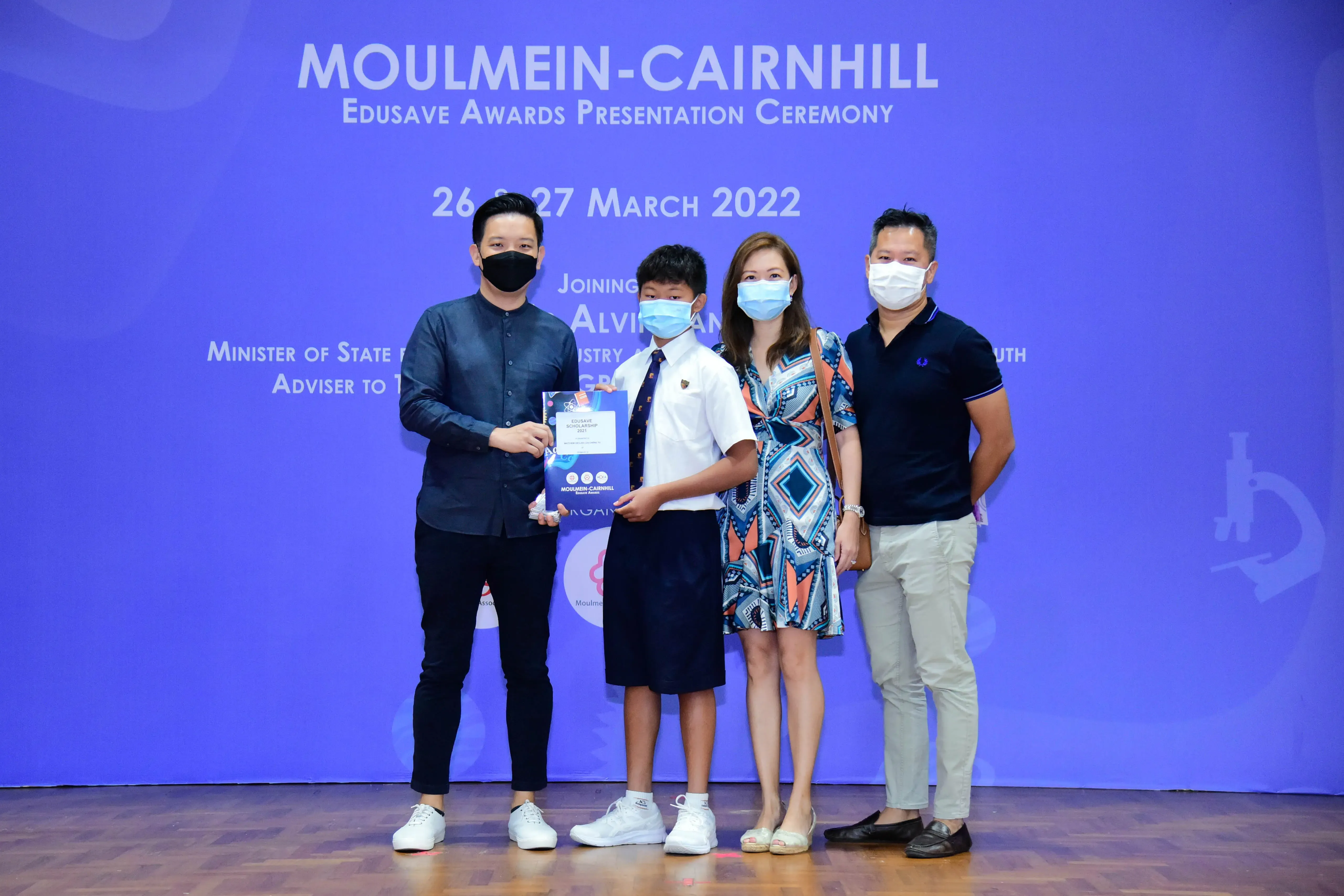 Four masked people pose at the Moulmein-Cairnhill Edusave Awards Presentation Ceremony on 26-27 March 2022.