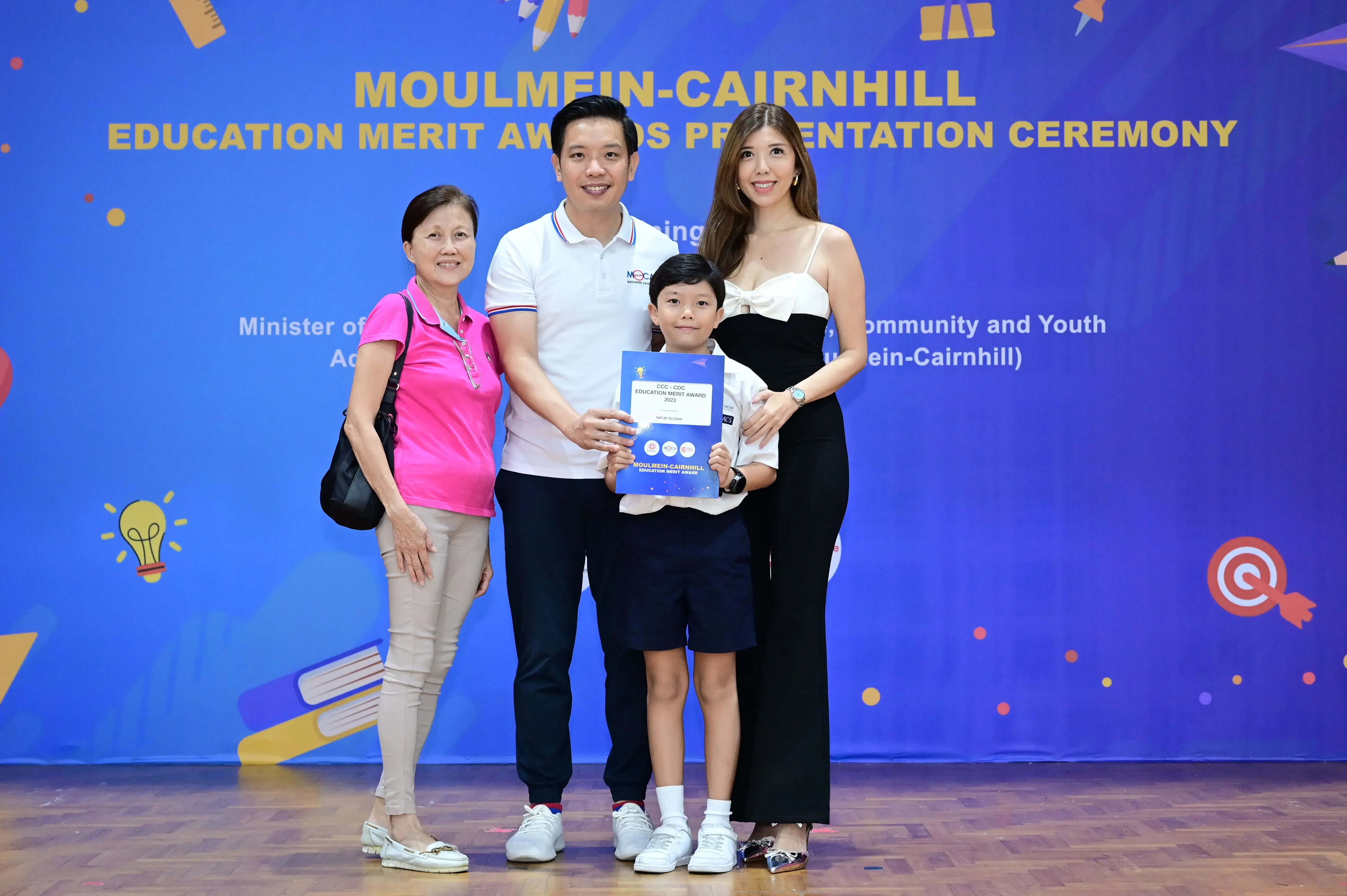 Four people pose with an award certificate at the Moulmein-Cairnhill Education Merit Awards Presentation Ceremony.
