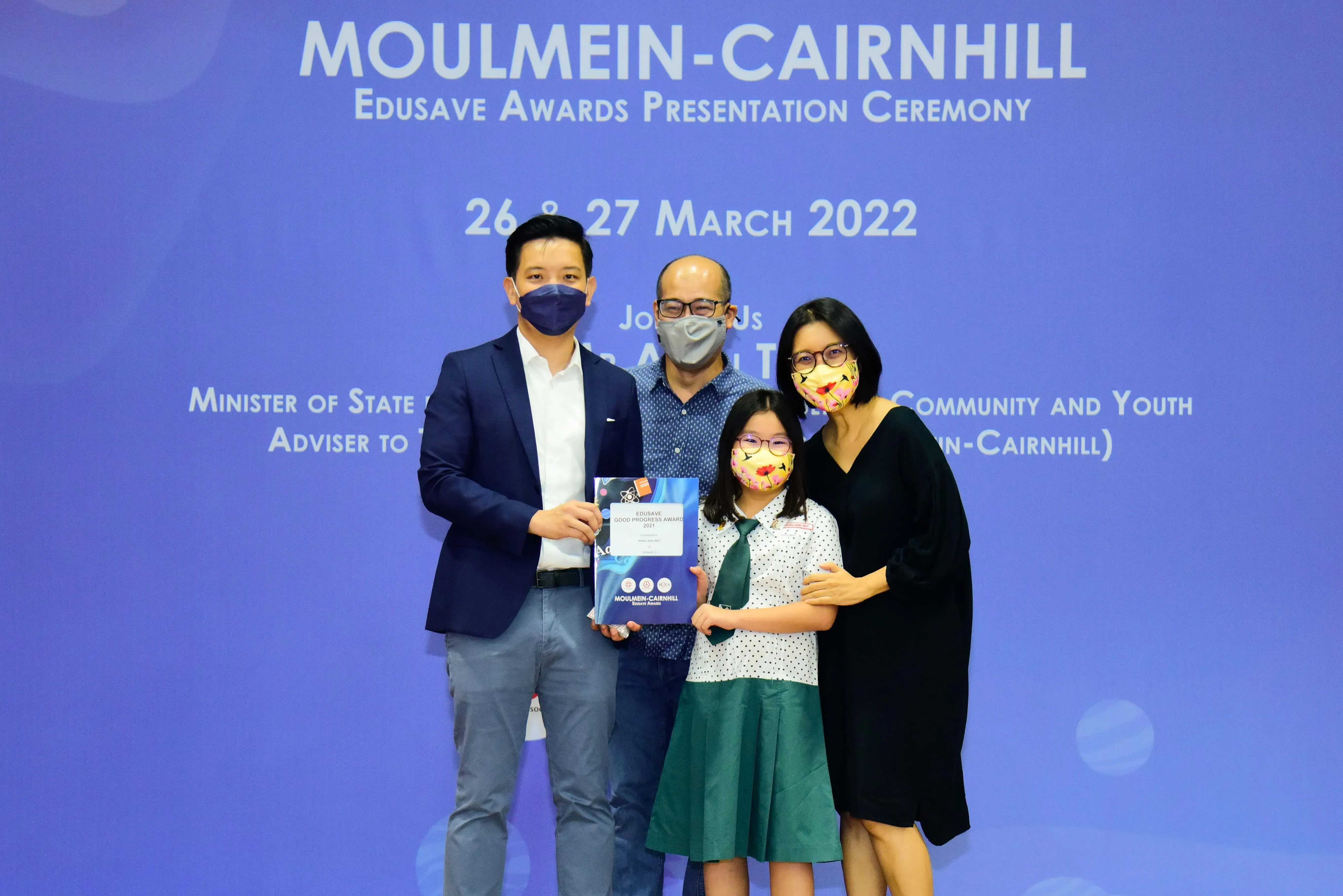 Four masked people pose at the Moulmein-Cairnhill Edusave Awards Ceremony on 26-27 March 2022.