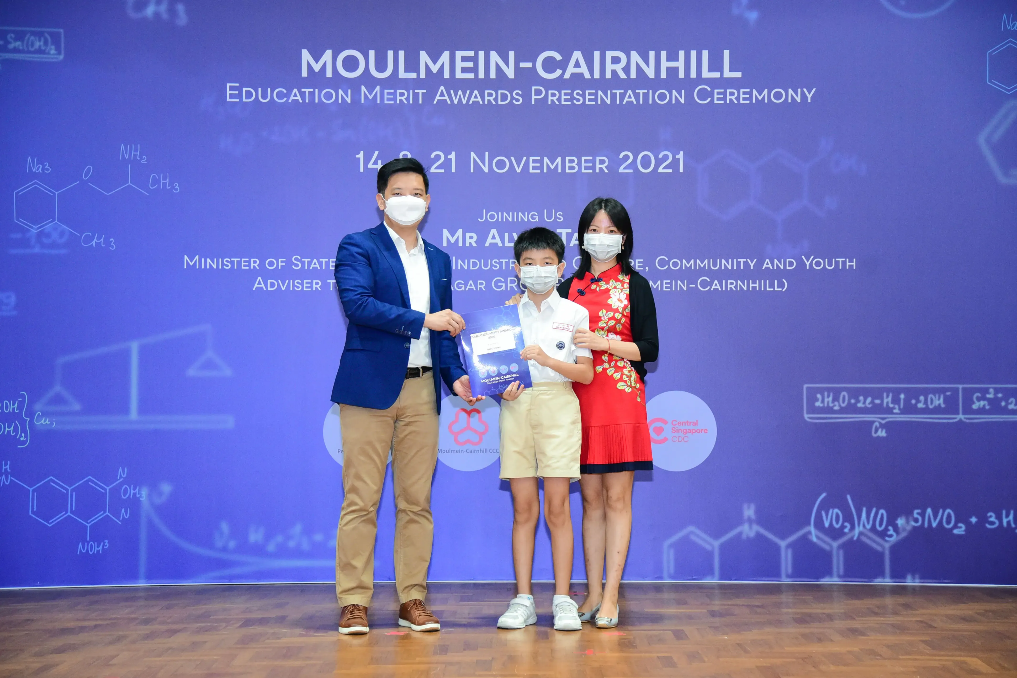 Three masked people pose at the Moulmein-Cairnhill Education Merit Awards ceremony on 14-21 November 2021.