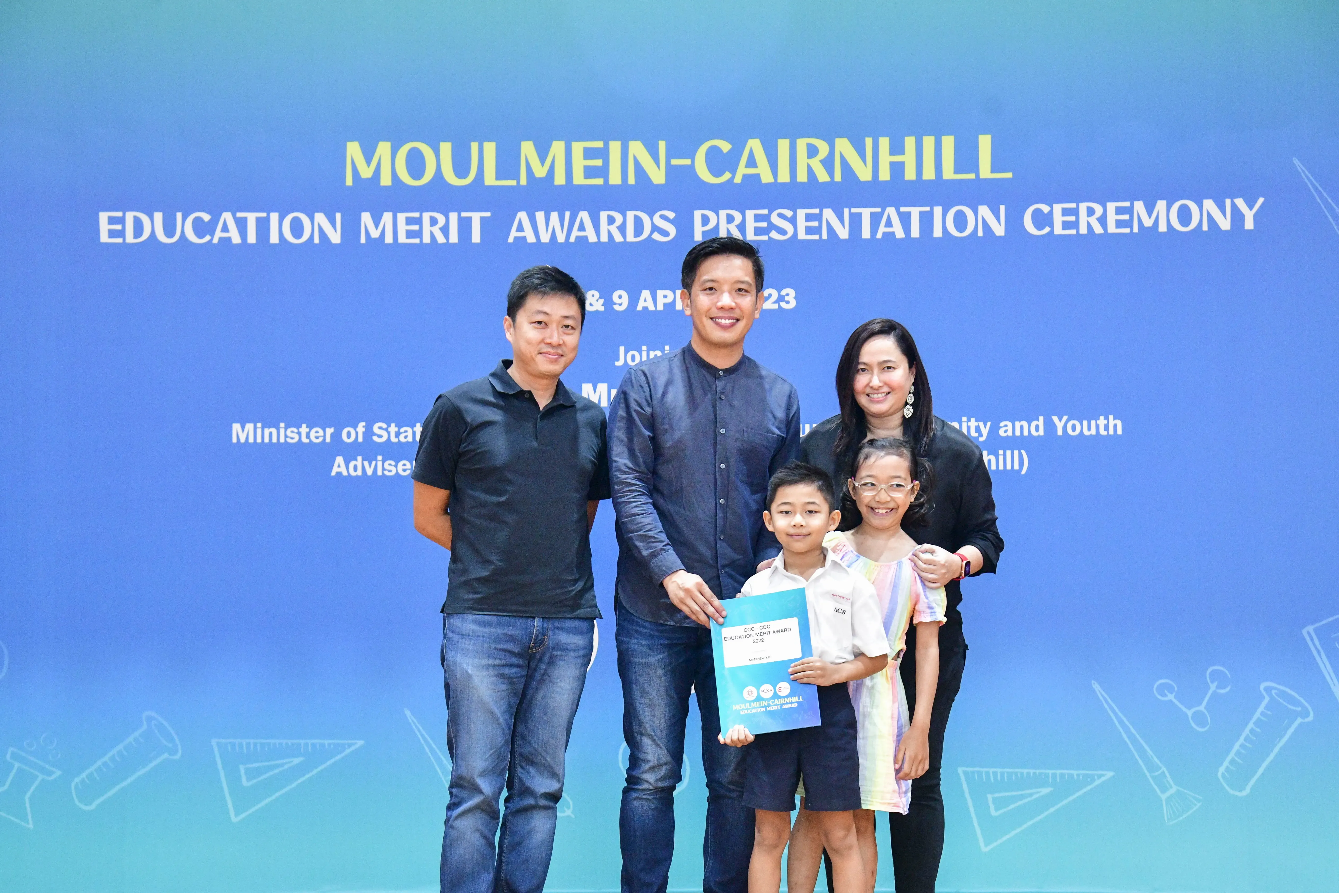 Three adults and two children pose at the Moulmein-Cairnhill Education Merit Awards Presentation Ceremony.
