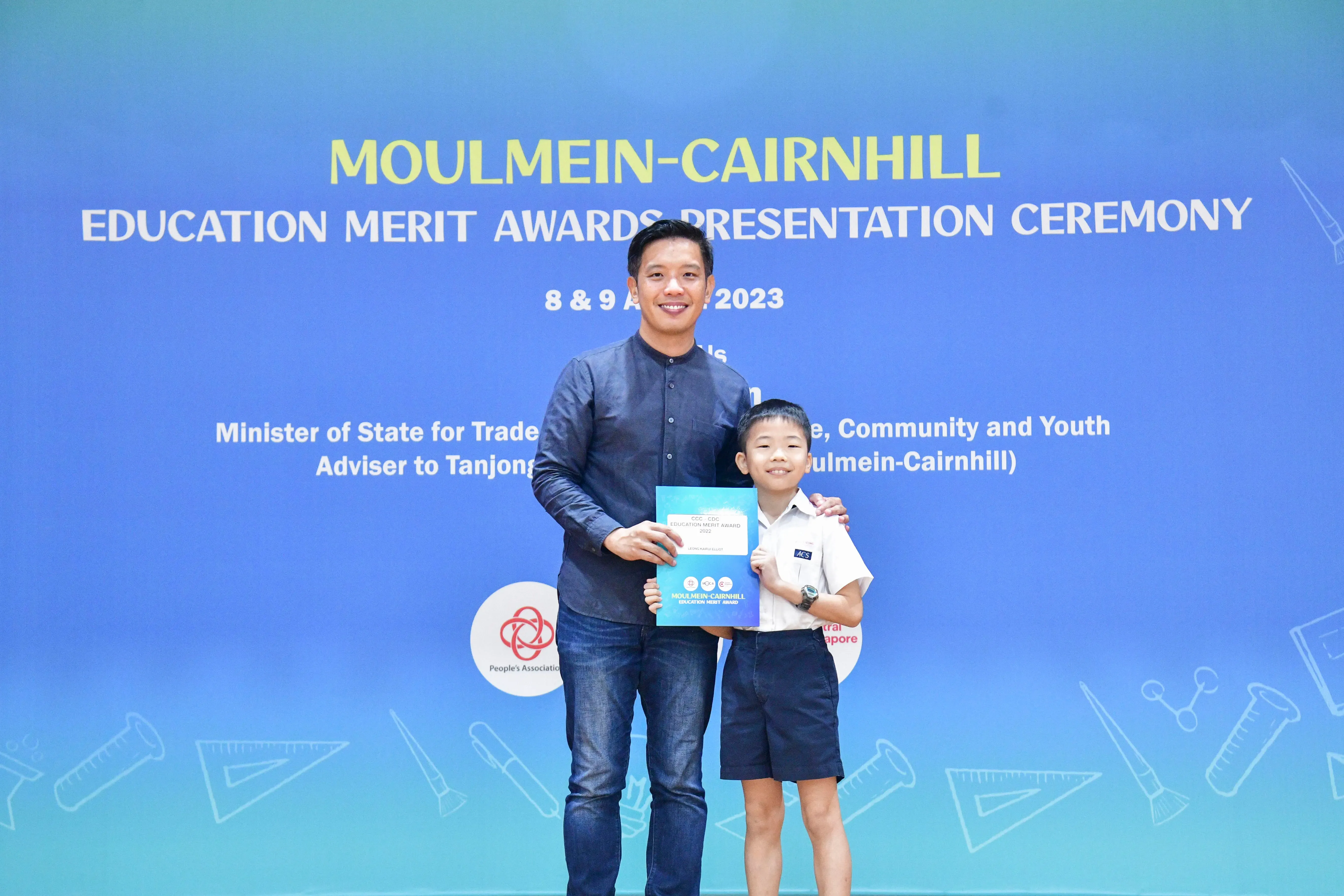 A man and a young boy pose together holding a certificate at the Moulmein-Cairnhill Education Merit Awards 2023.