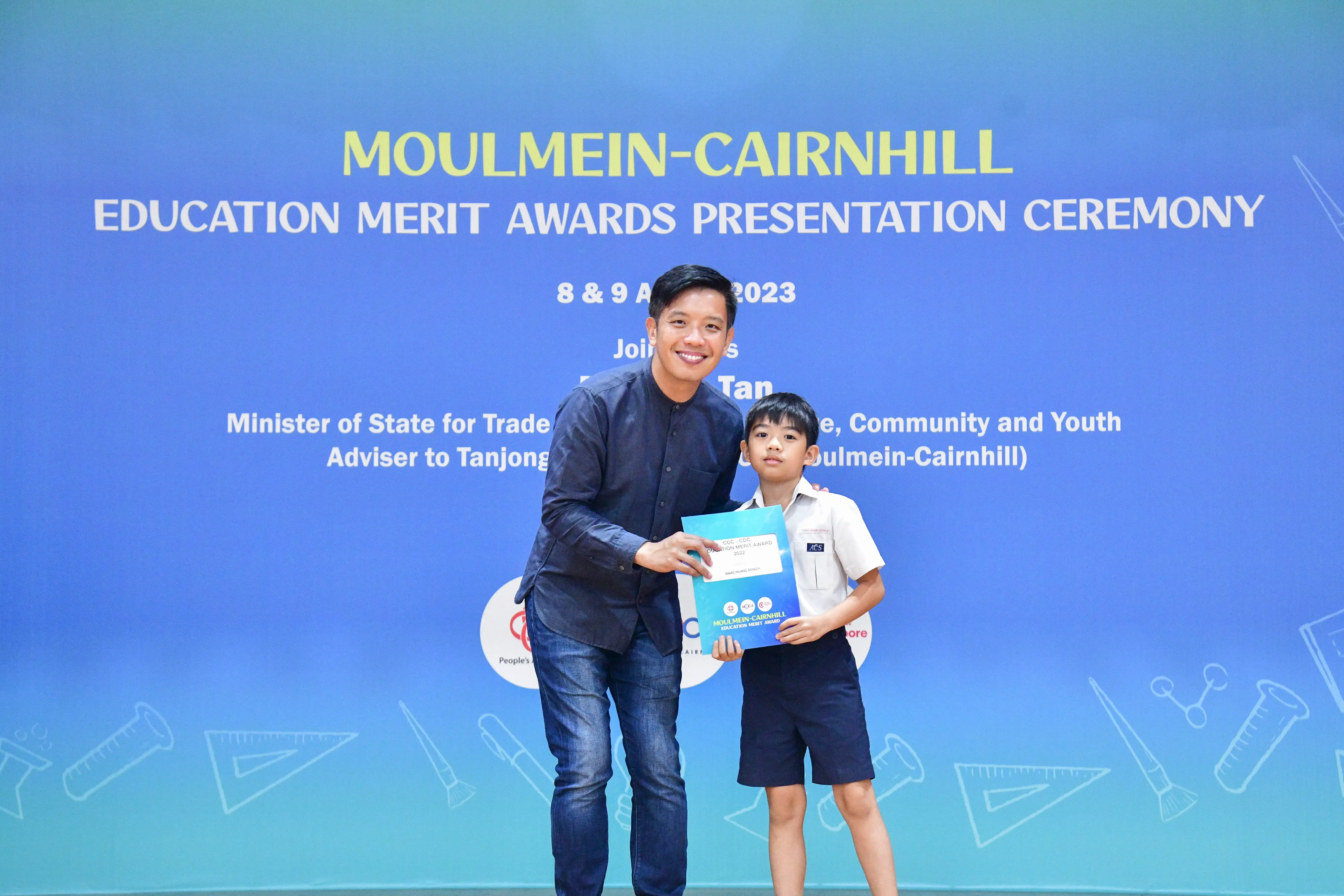 A man and a young boy hold a certificate together at the Moulmein-Cairnhill Education Merit Awards 2023.