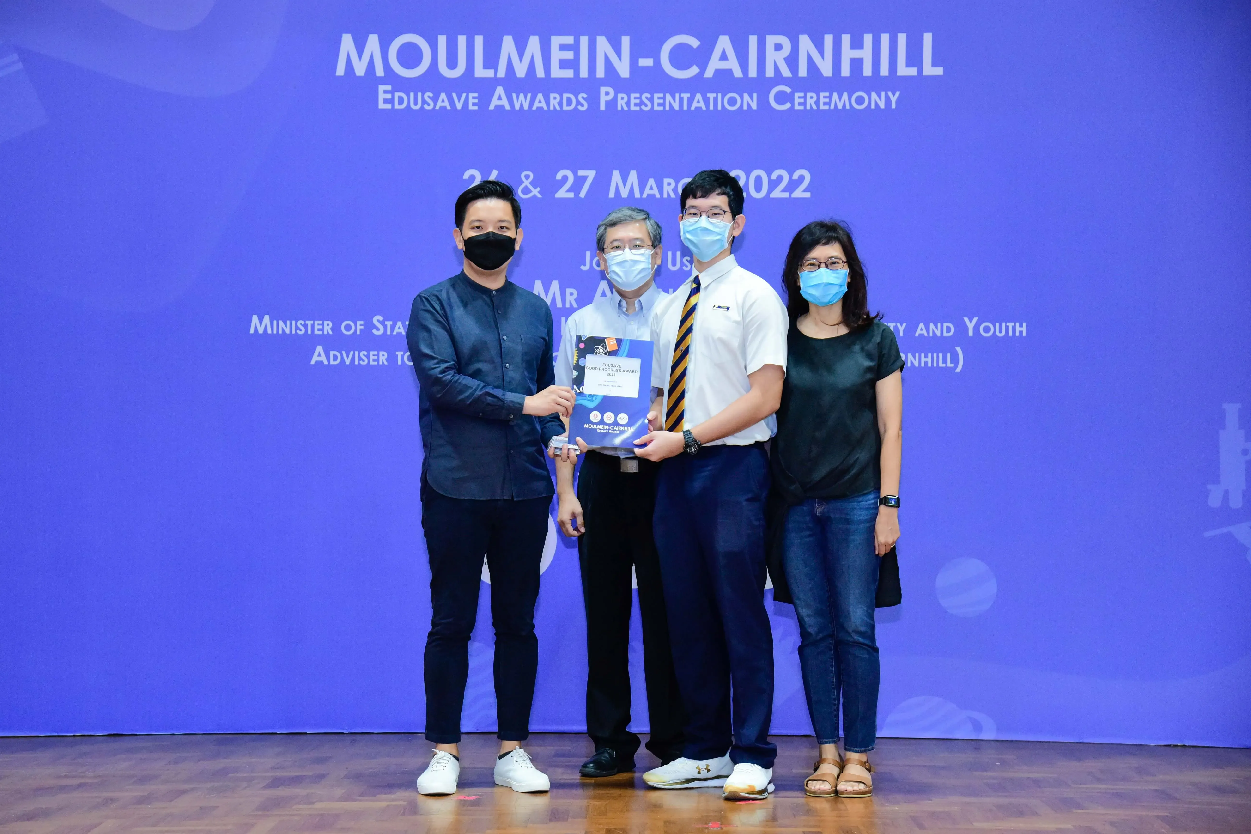 Four masked people pose at the Moulmein-Cairnhill Edusave Awards Presentation Ceremony on 26 and 27 March 2022.