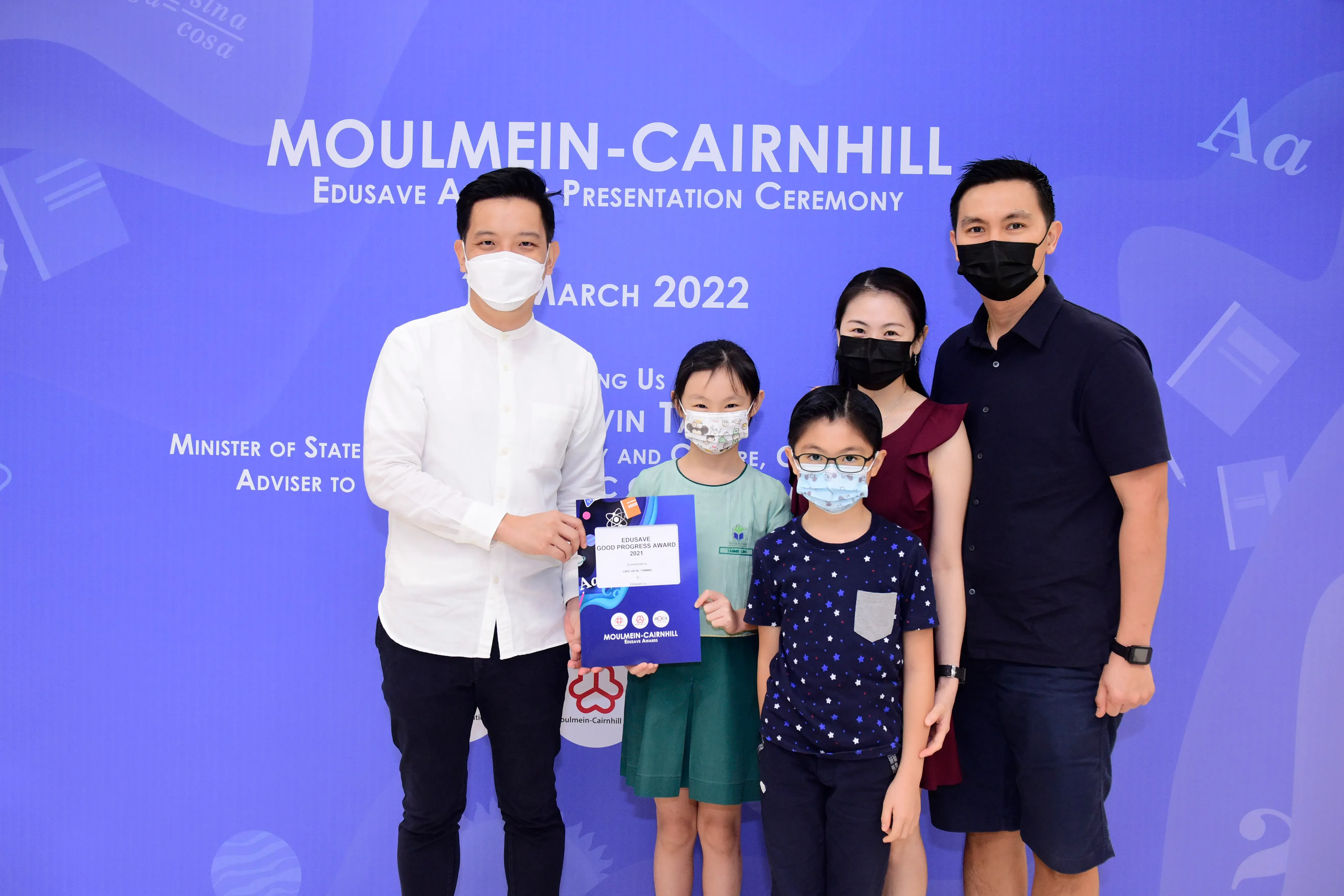 Five masked people pose at the Moulmein-Cairnhill Edusave Award Presentation Ceremony in March 2022.