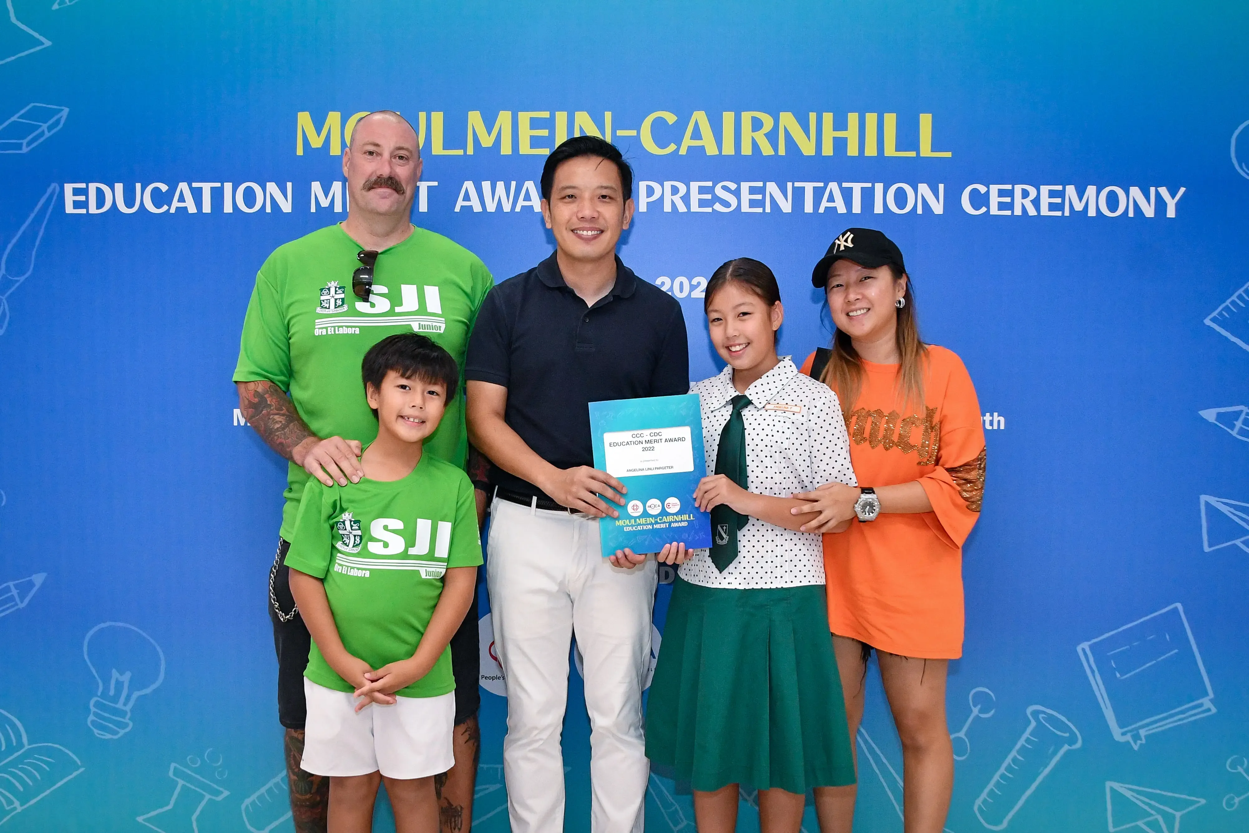 Five people pose with an award certificate at the Moulmein-Cairnhill Education Merit Award Presentation Ceremony.