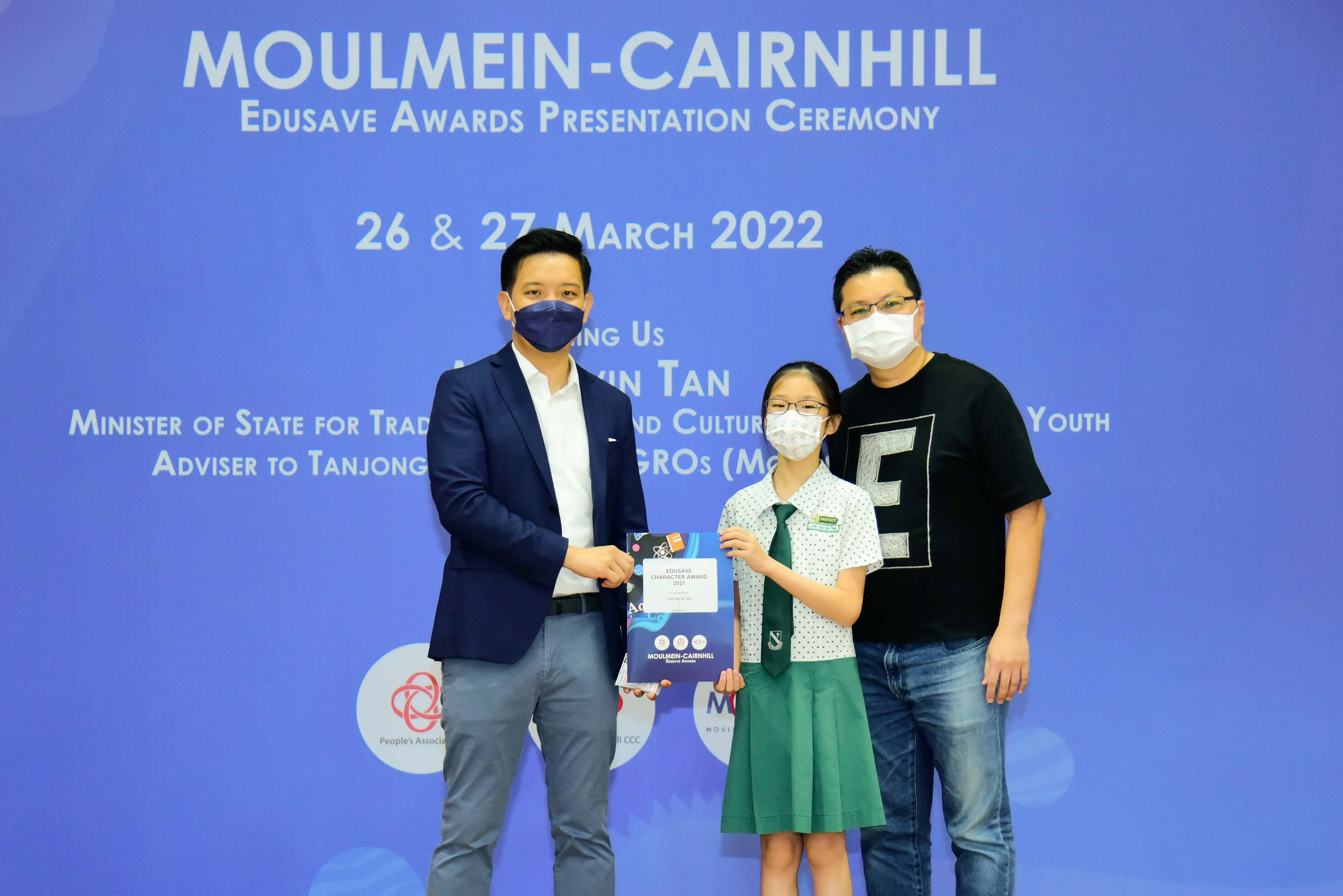 Three masked people pose at the Moulmein-Cairnhill Edusave Awards Presentation Ceremony on 26-27 March 2022.
