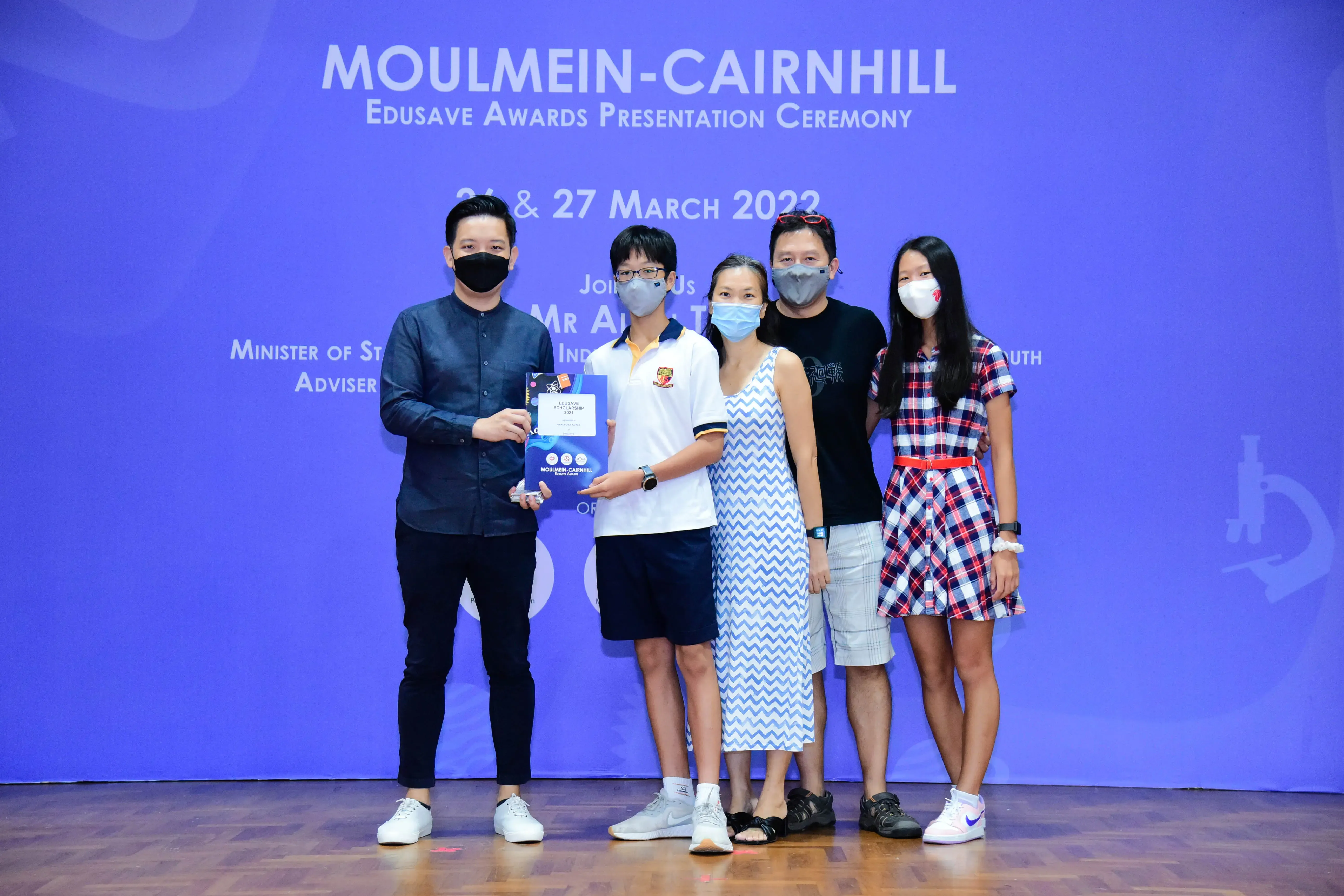 Five masked people pose at the Moulmein-Cairnhill Edusave Awards Presentation Ceremony on 26-27 March 2022.
