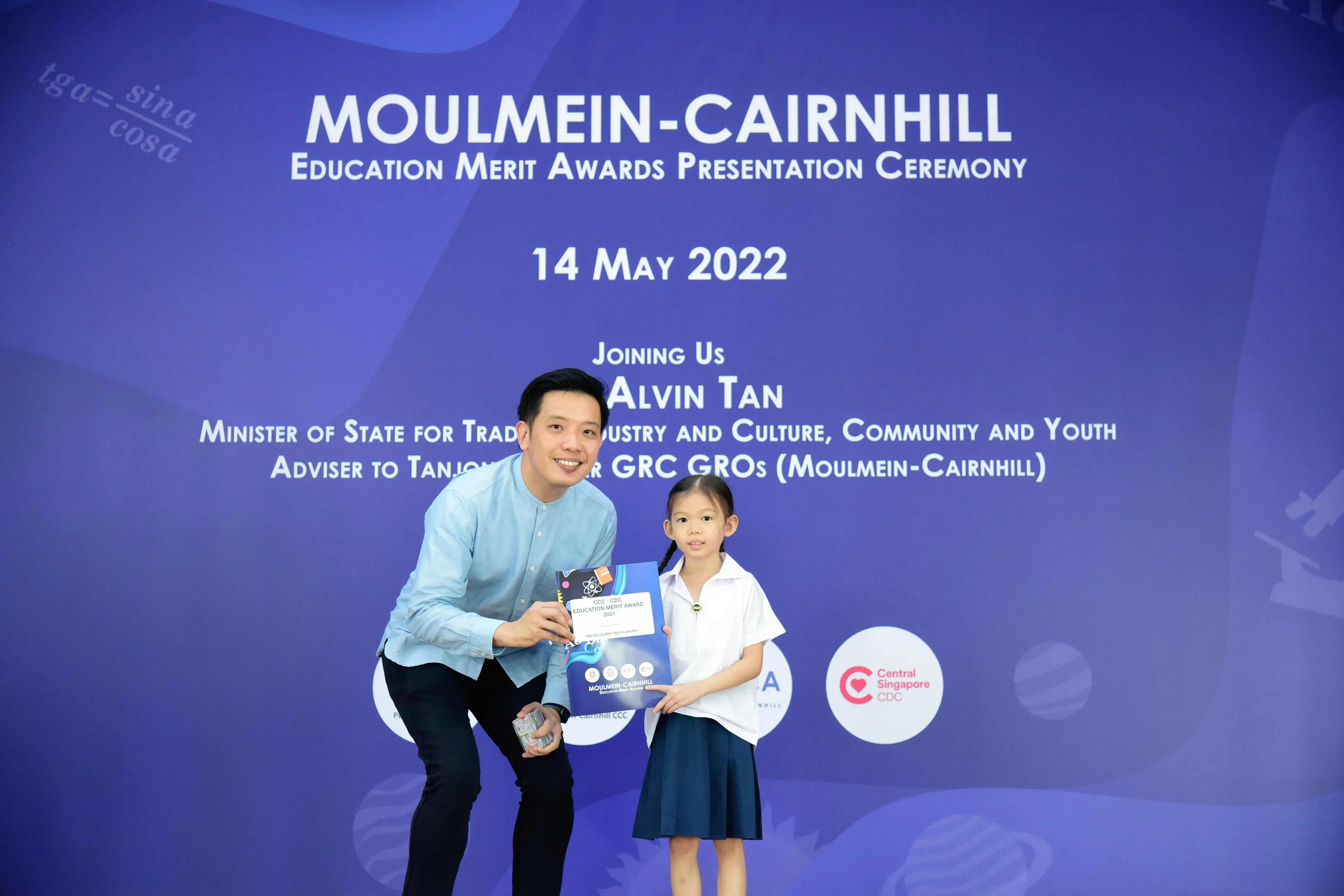 A man and a young girl hold an award certificate at the Moulmein-Cairnhill Education Merit Awards ceremony on 14 May 2022.