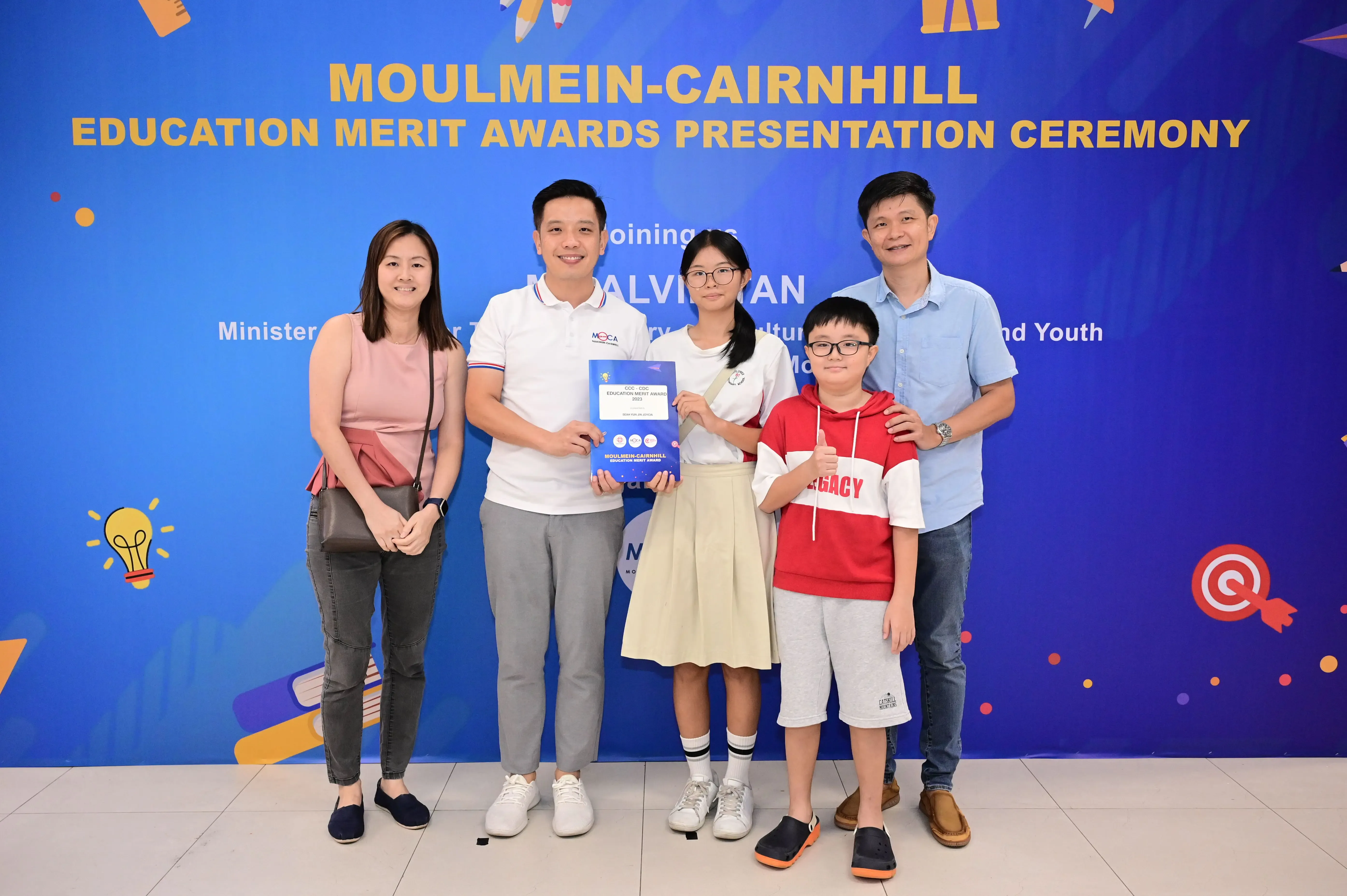 Five people pose with an award certificate at the Moulmein-Cairnhill Education Merit Awards Presentation Ceremony.
