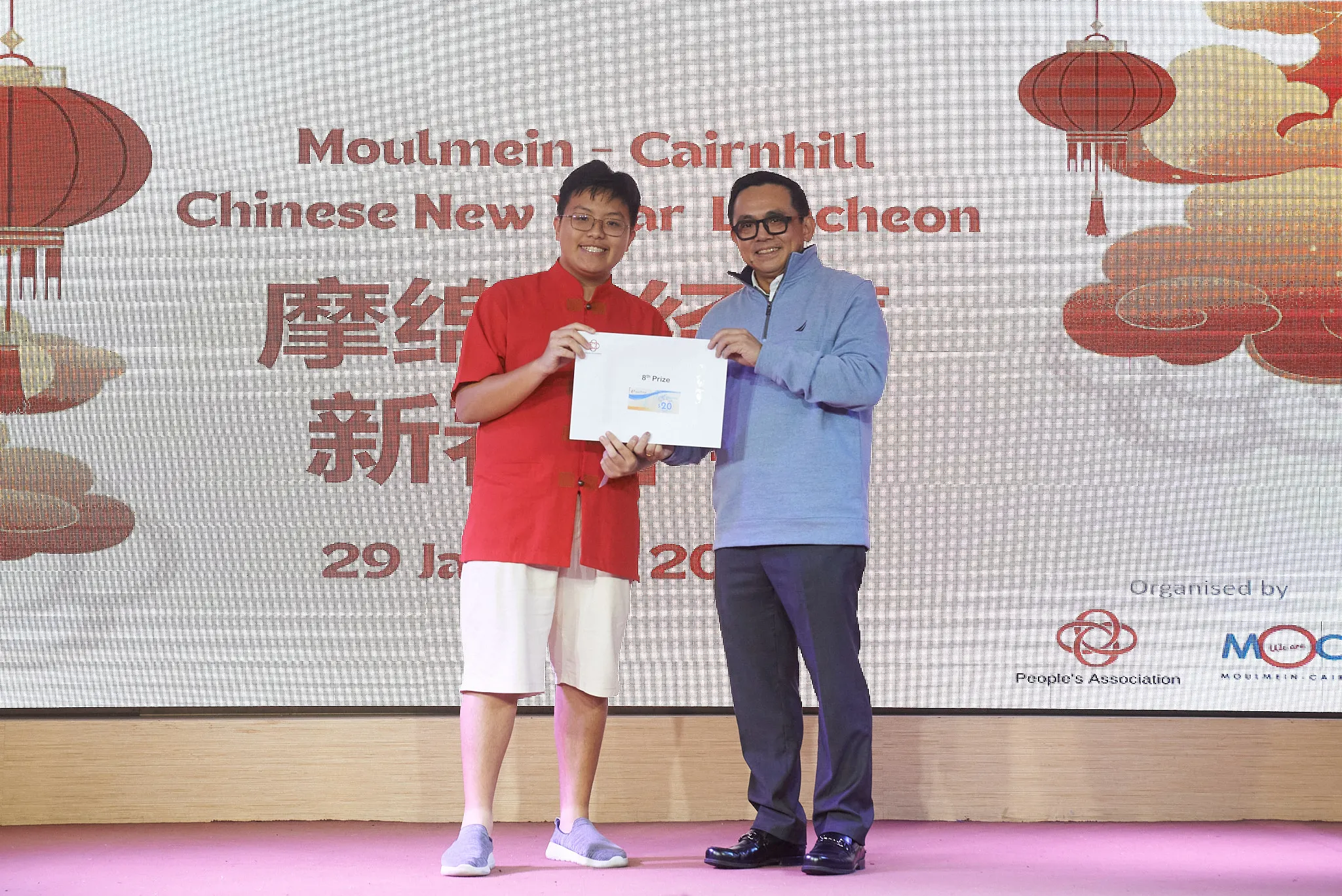 Two people hold an 8th Prize envelope at the Moulmein-Cairnhill Chinese New Year Luncheon on 29 January.