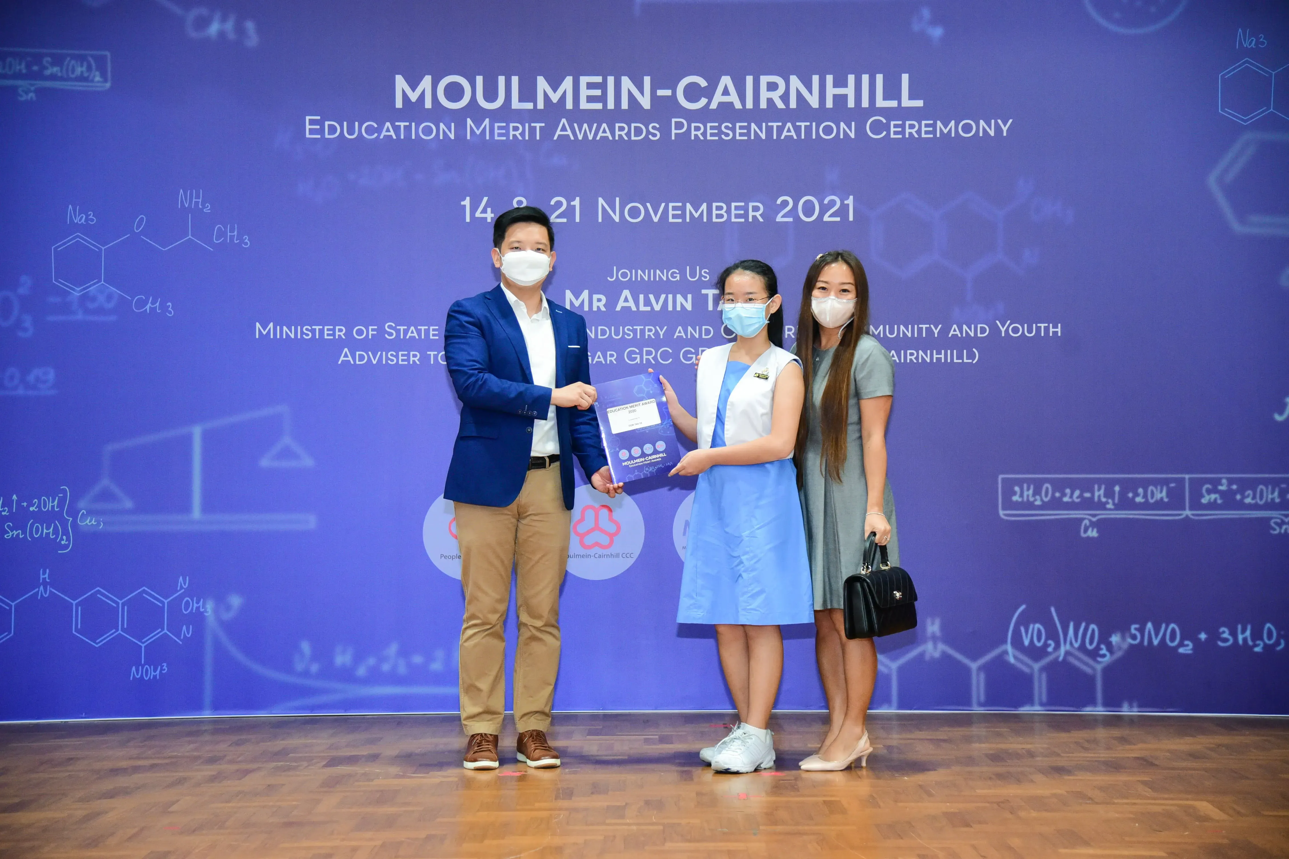 Three masked people pose at the Moulmein-Cairnhill Education Merit Awards Ceremony on 14 and 21 November 2021.