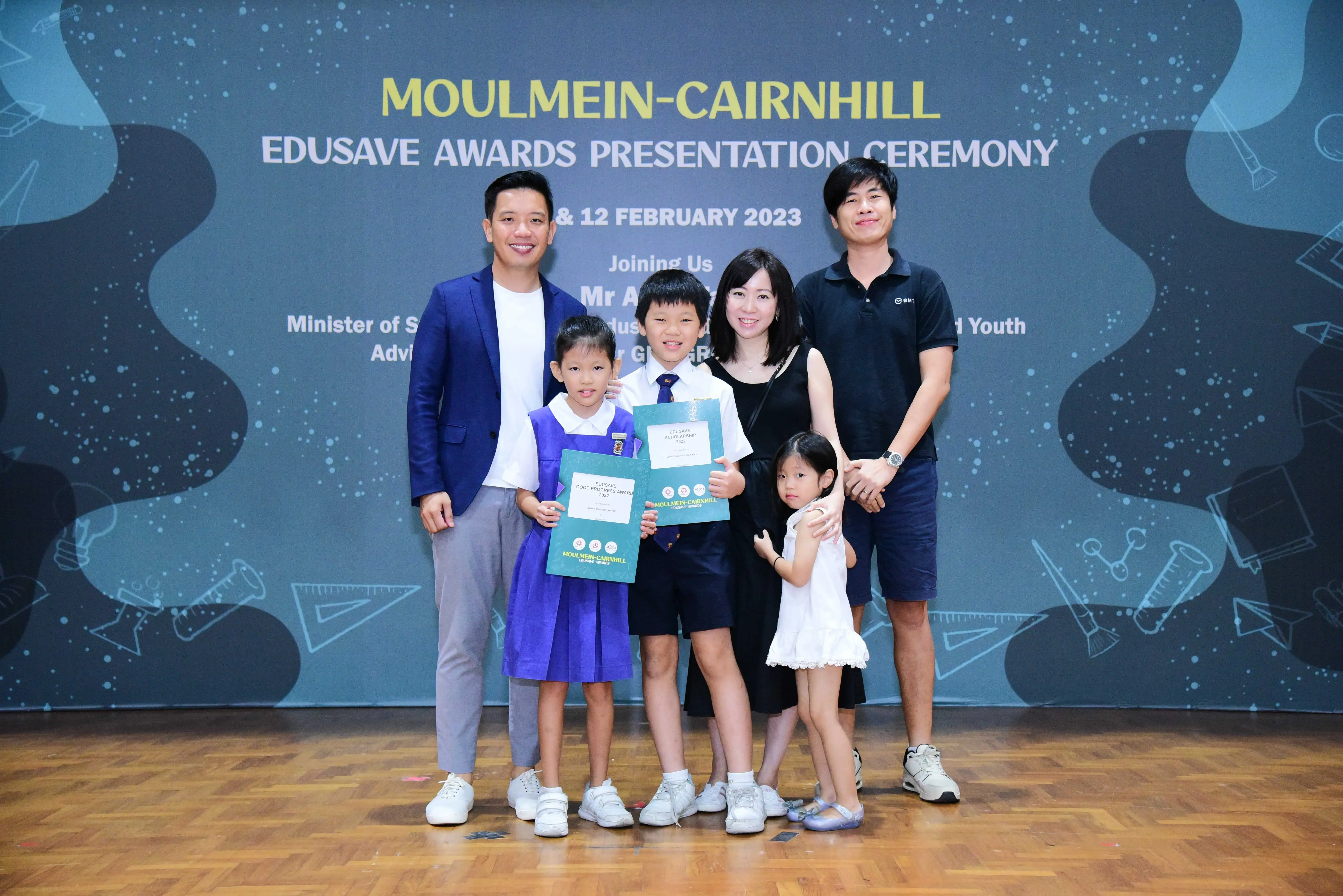 Family of five posing with award certificates at the Moulmein-Cairnhill Edusave Awards Ceremony, February 2023.